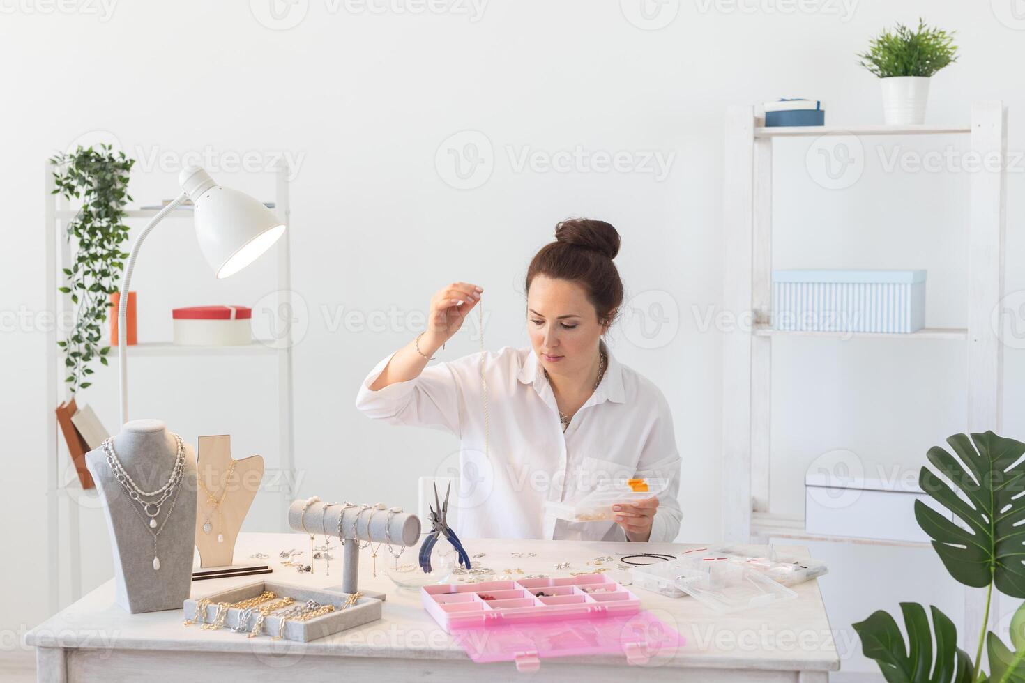 Professional accessories designer making handmade jewelry in studio workshop. Creativity and handmade concept. photo