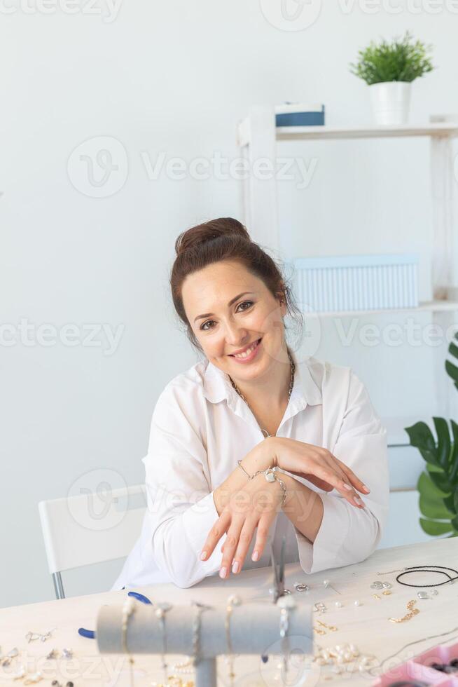 Professional accessories designer making handmade jewelry in studio workshop. Hobby and handmade concept. photo