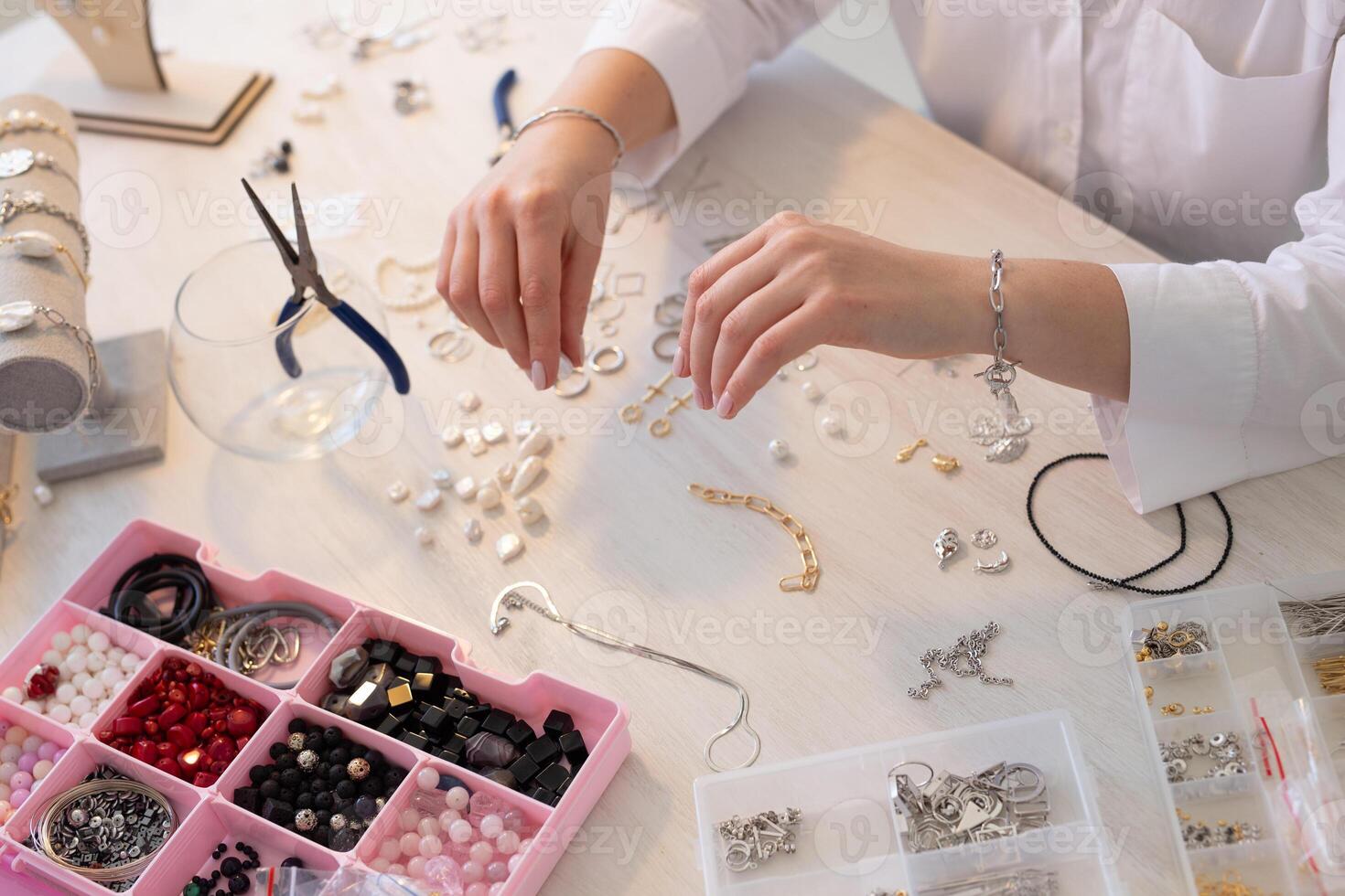 Professional accessories designer making handmade jewelry in studio workshop. Fashion, creativity and handmade close-up concept. photo