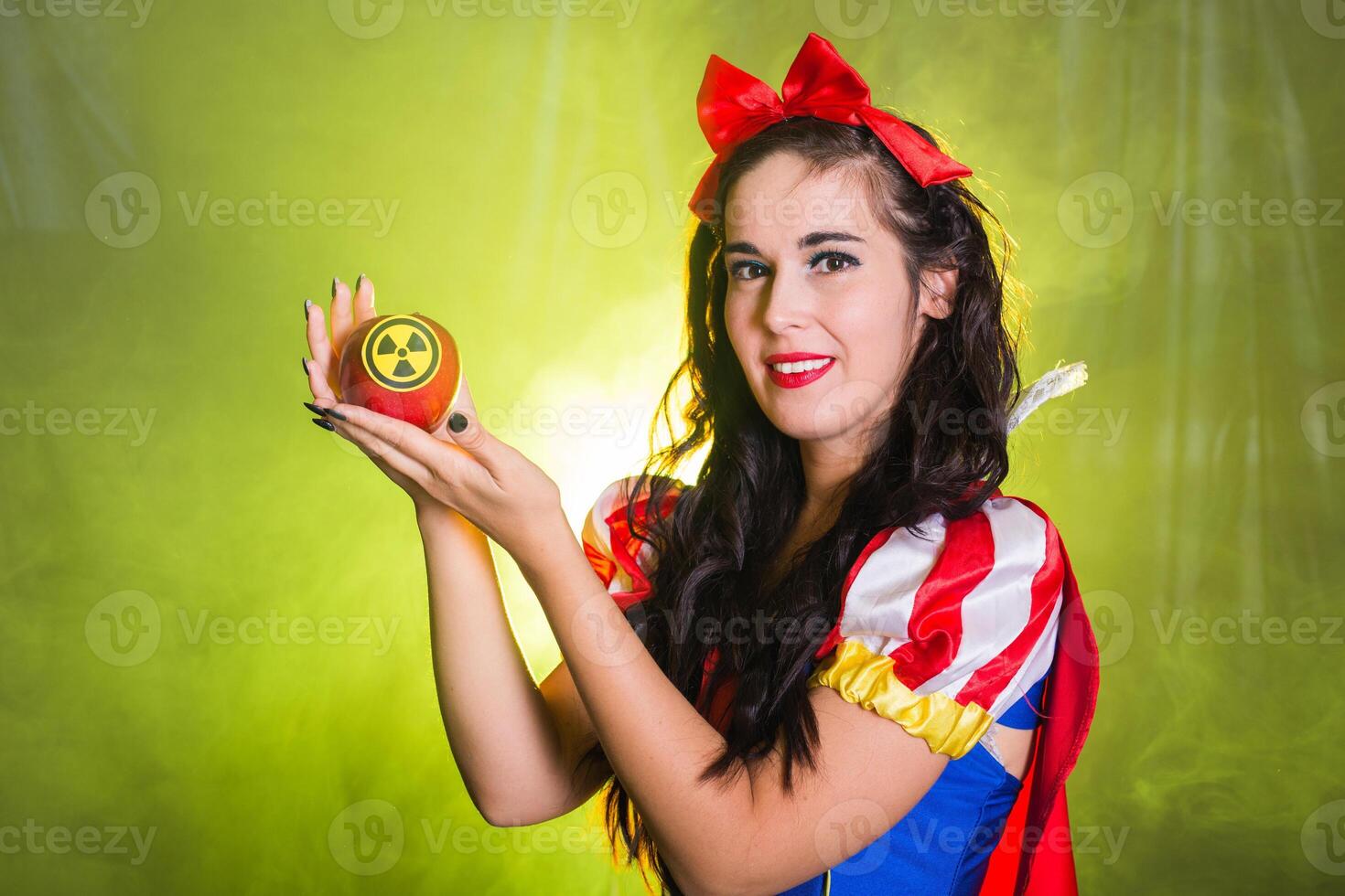Happy woman wearing a fairy tale dress holding an apple with radiation symbol. Environmental problems concept, radioactive disaster as danger on nature. photo