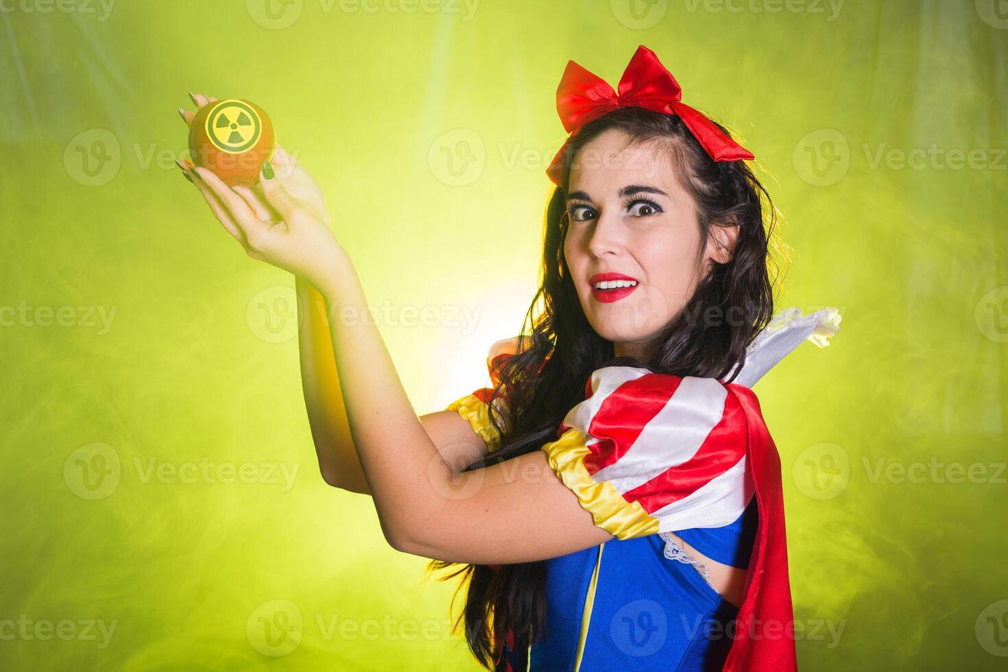 Crazy Woman dressed as fairytale character holds Radioactive atomic nuclear ionizing radiation danger warning symbol on apple. Nuclear and radiation measurement concept. photo