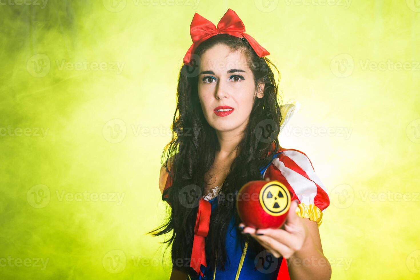 Portrait female wearing a fairy tale dress holding an apple with radiation symbol. Environmental problems concept, radioactive disaster as danger on nature. photo