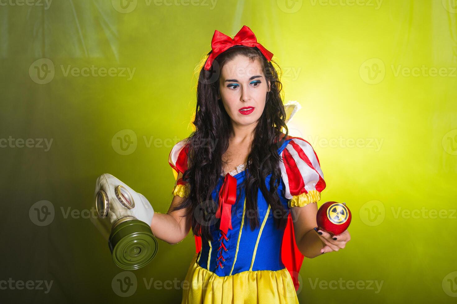 Woman dressed as fairytale character holds Radioactive atomic nuclear ionizing radiation danger warning symbol on apple. Nuclear and radiation photo