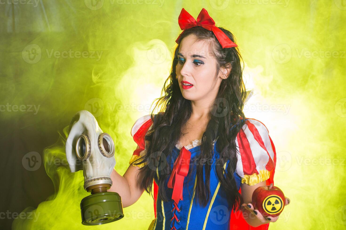 Woman in fairy tale dress holding hazardous radioactive apple. Nuclear and radiation measurement concept. photo