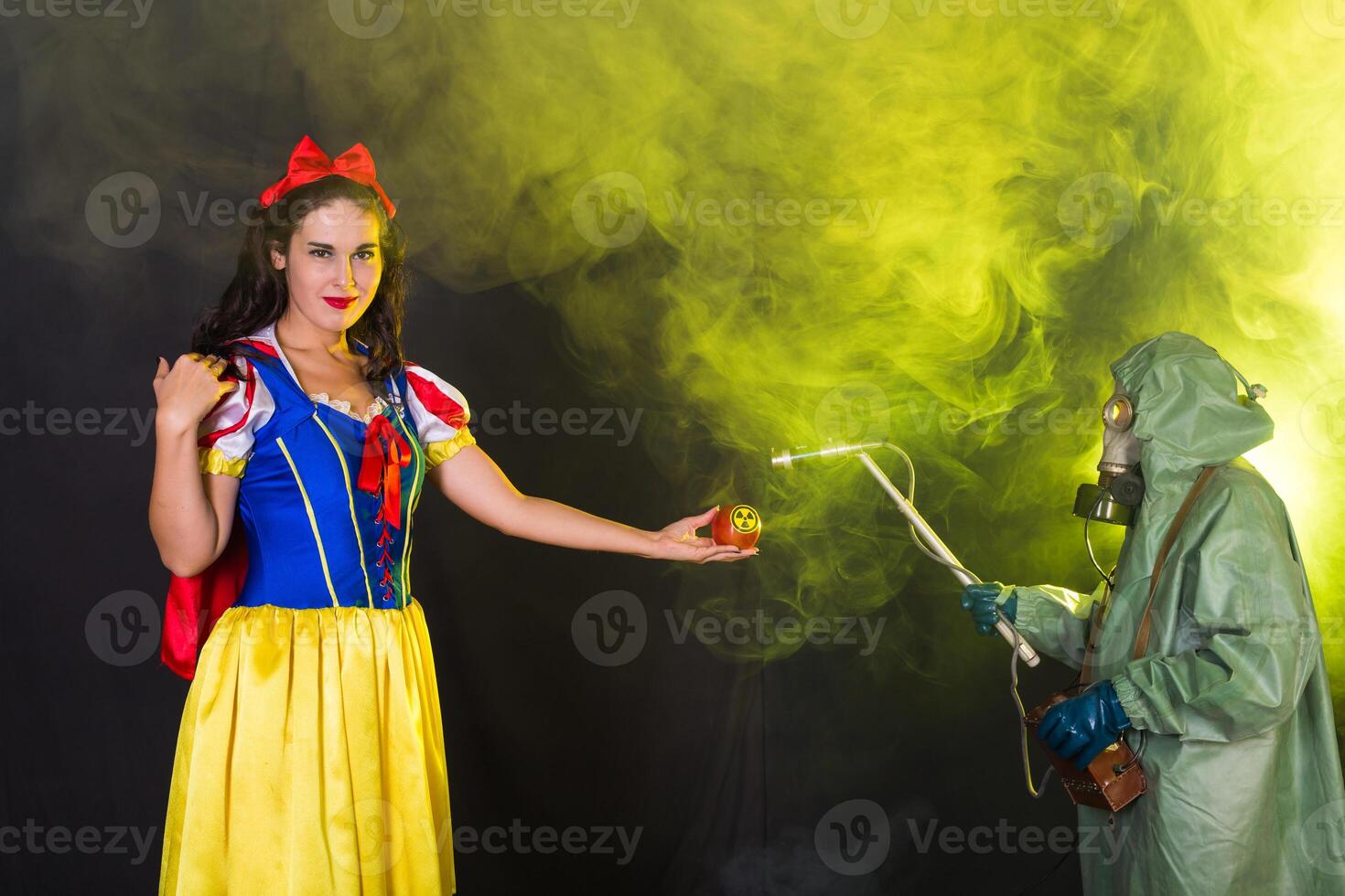 Woman dressed as fairytale female holds Radioactive atomic nuclear ionizing radiation danger warning symbol on apple. Nuclear and radiation measurement concept. photo