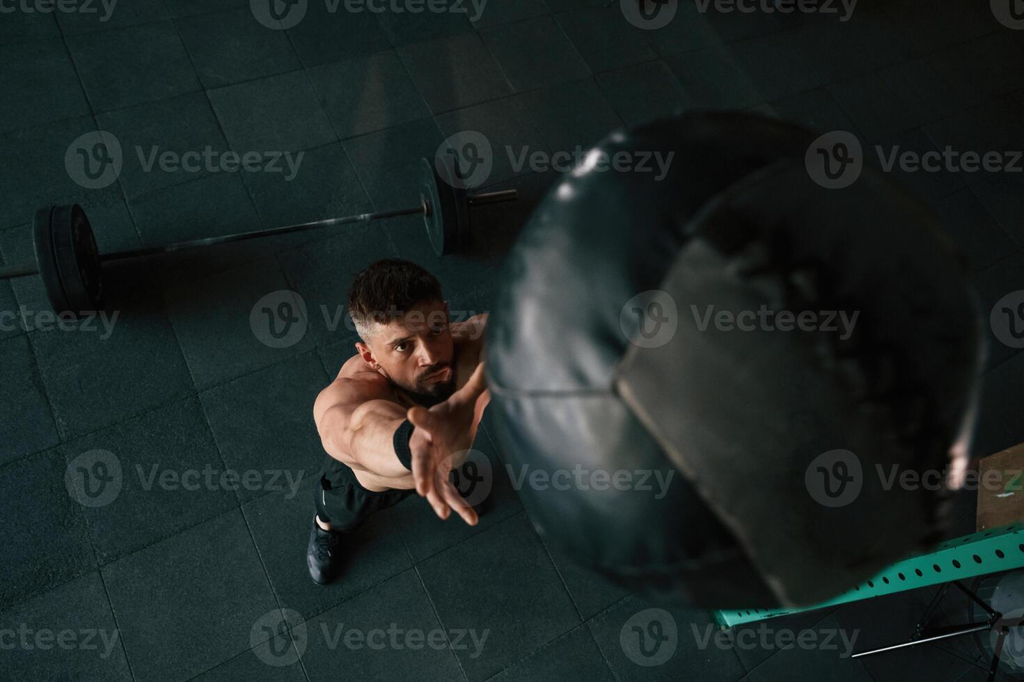 Top view, throwing ,the ,,fitness ball. Strong muscular man is working out in the gym photo