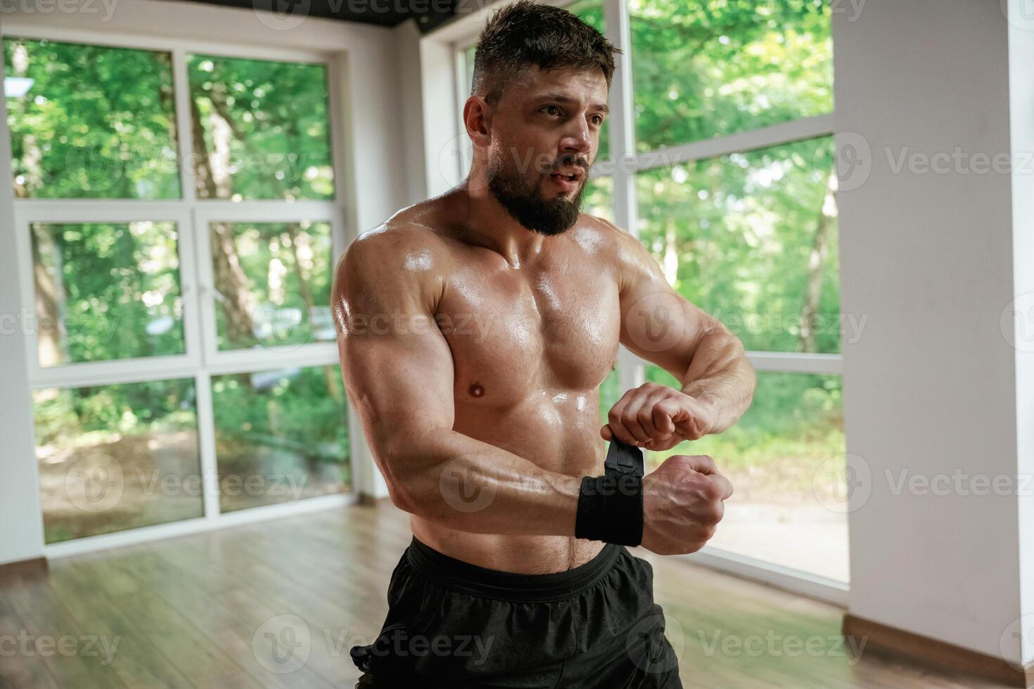 Wearing the protective bandage ,,on hands. Strong muscular man is working out in the gym photo