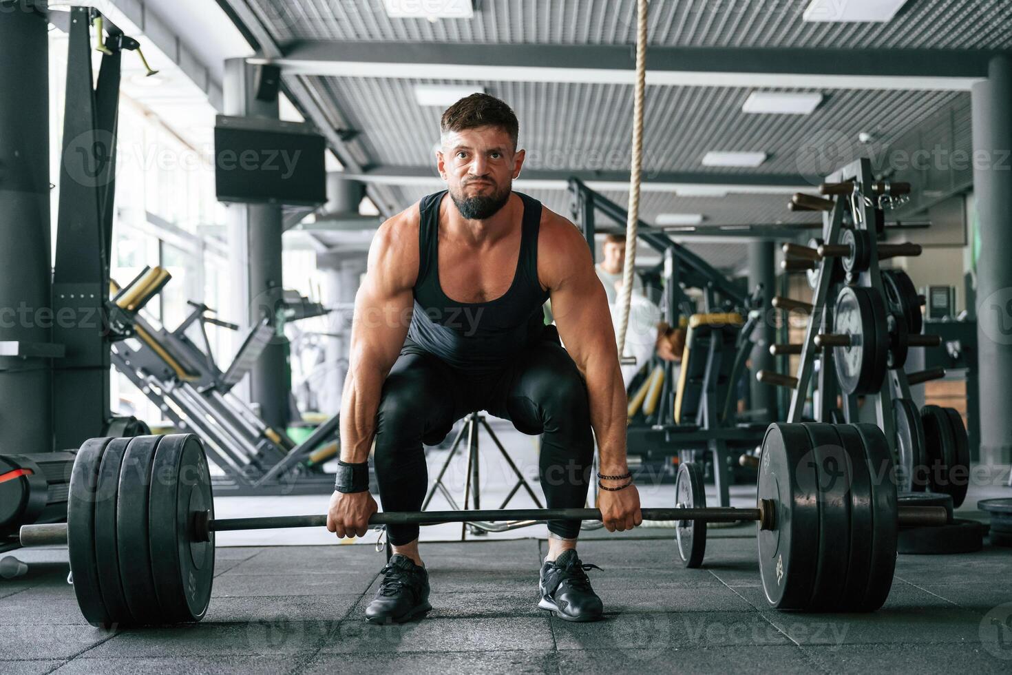 Lifts, a barbell. Strong ,,muscular man is working out in the gym photo