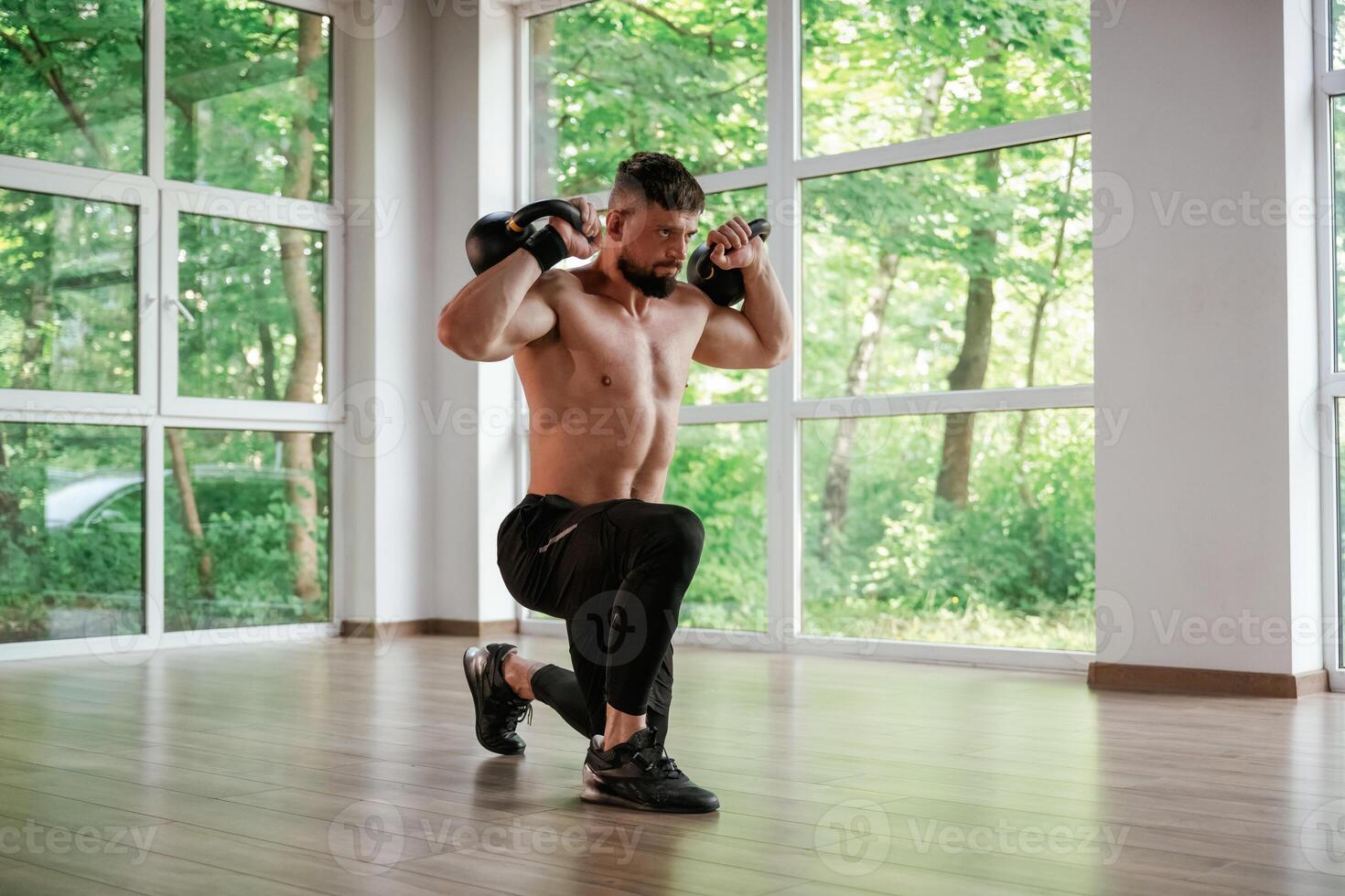 With heavy, dumbbells. Strong muscular man is working out in the gym photo