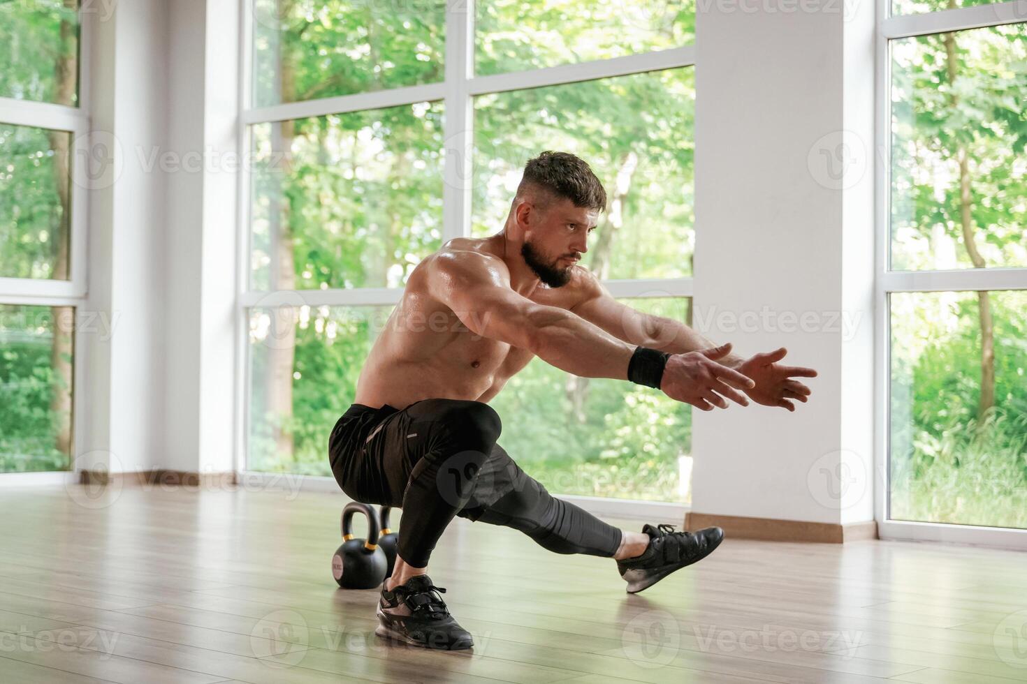 Focused, at the exercise. Strong muscular man is working out in the gym photo