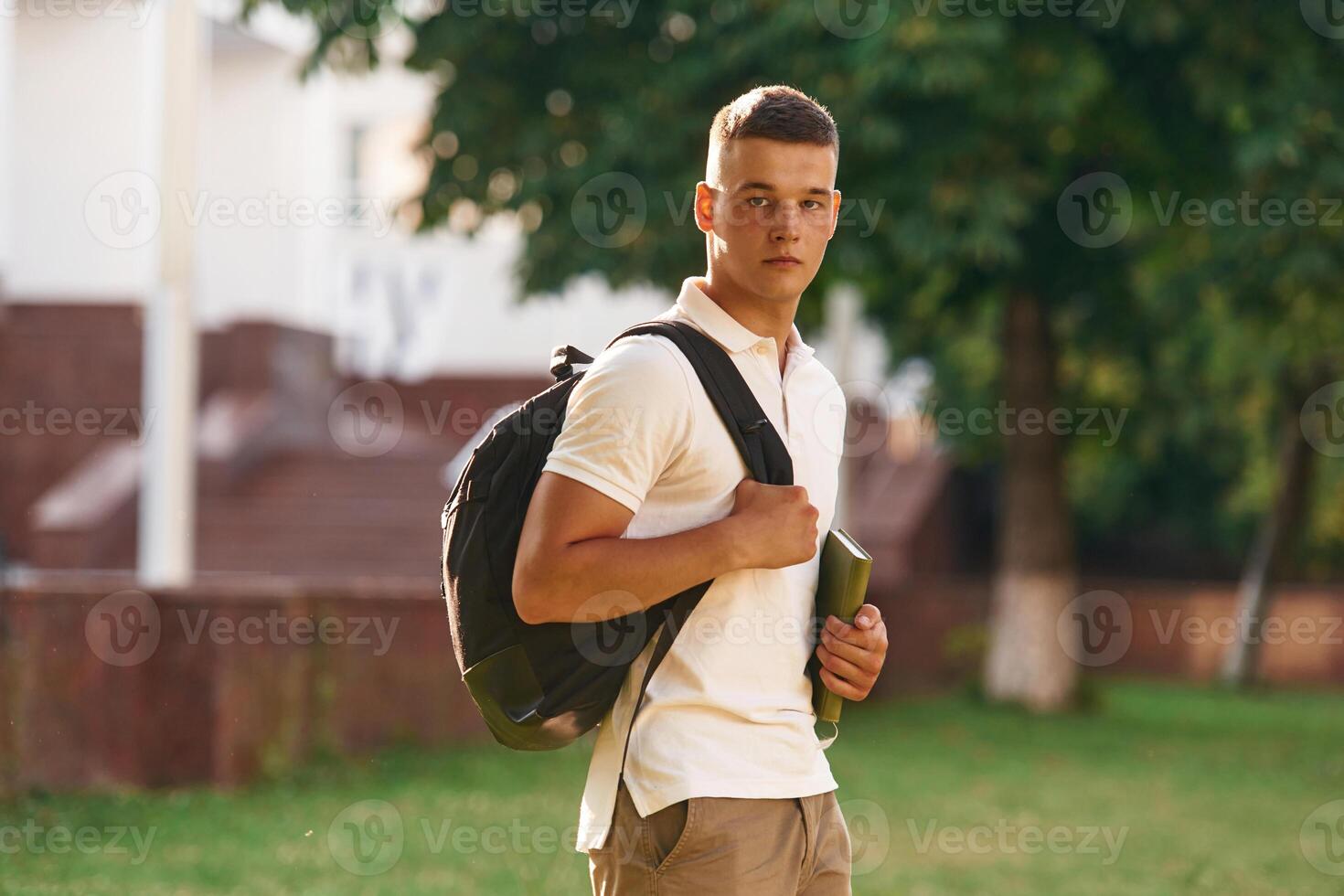 Young male student is outdoors. photo
