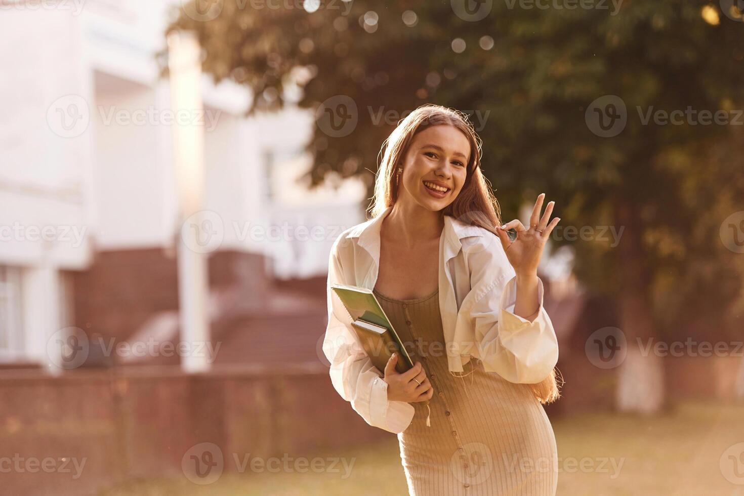 Standing, front, view. Beautiful ,female student is outdoors near the university photo