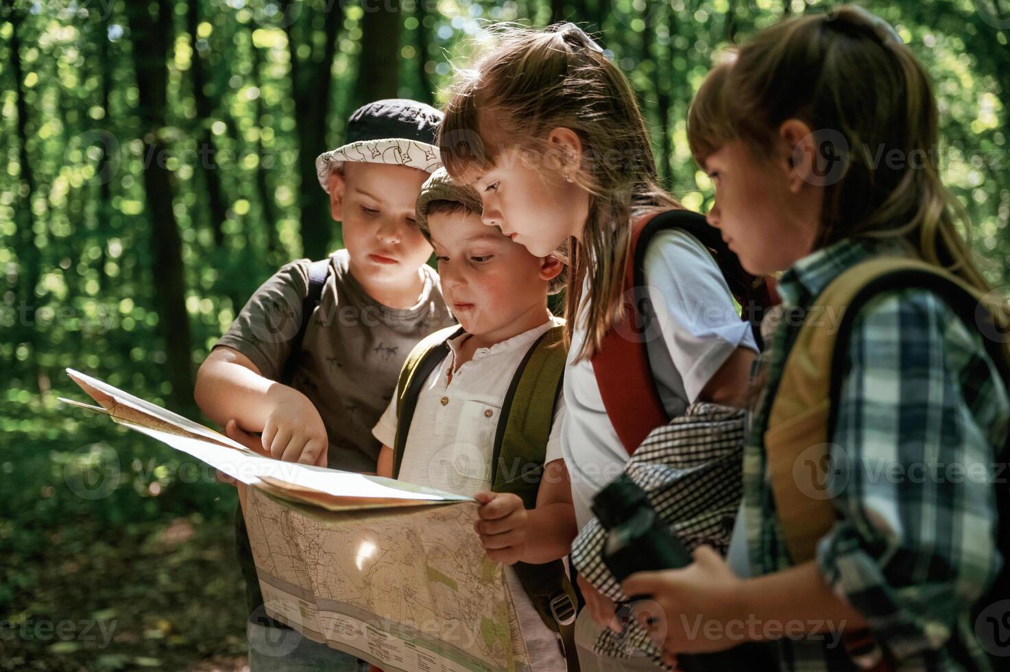Paper map, in, hands. Kids in forest at summer daytime together photo