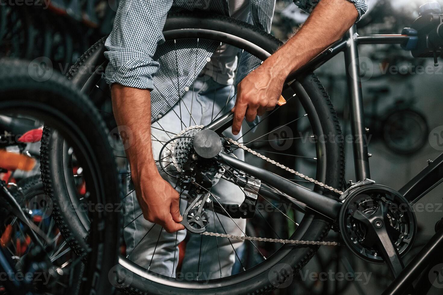 Close up view of man's hands that is repairing bicycle. photo