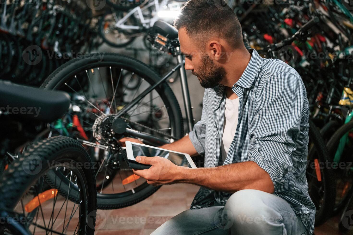Using ,digital ,tablet. Repair, man in bicycle shop, working in store photo