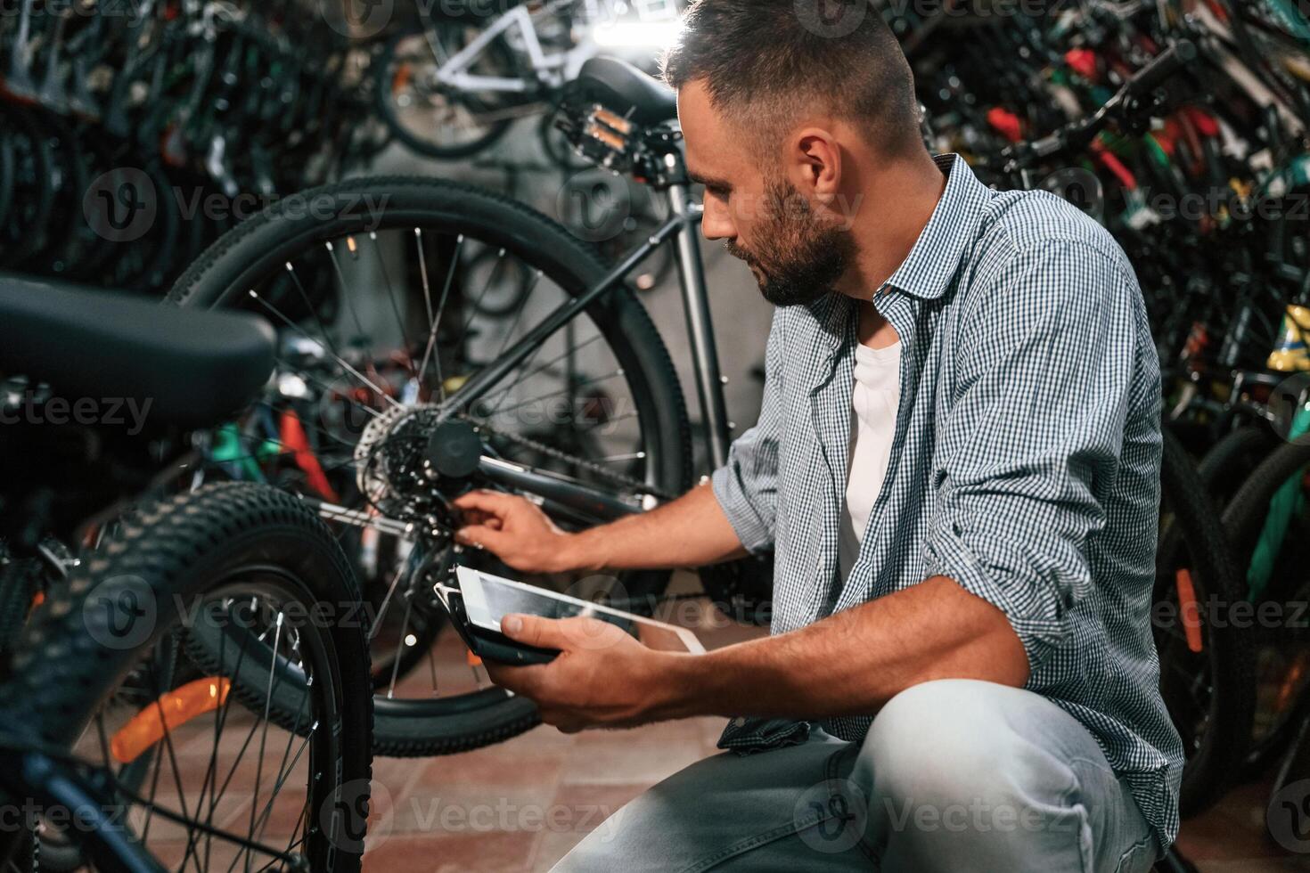 Using digital tablet. Repair man ,,,in bicycle ,shop, working in store photo