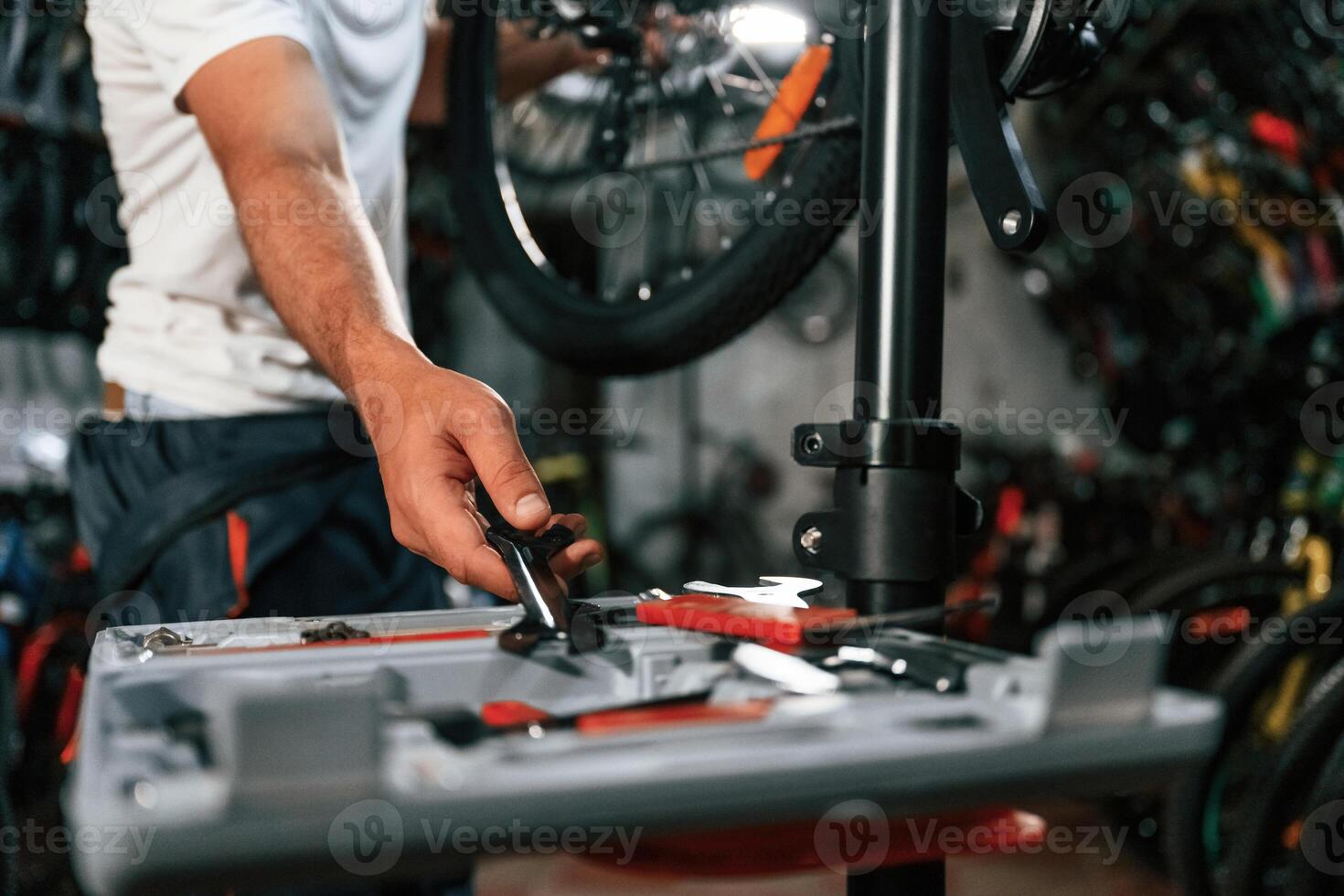 Taking ,wrench. Close up view of man's hands that is repairing bicycle photo