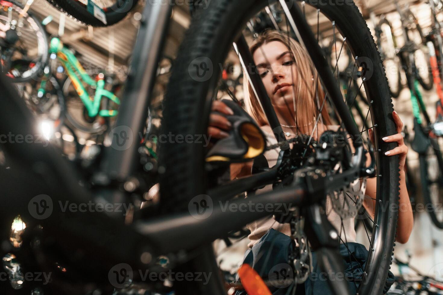 Repair woman in bicycle shop, working in, store photo