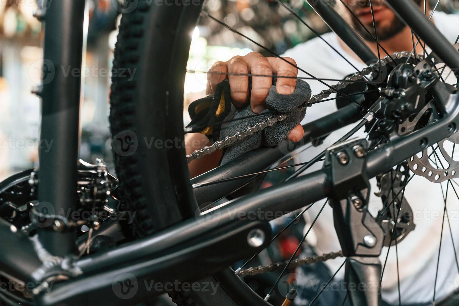 Rear ,wheel ,,adjustment. Repair man in bicycle shop, working in store photo