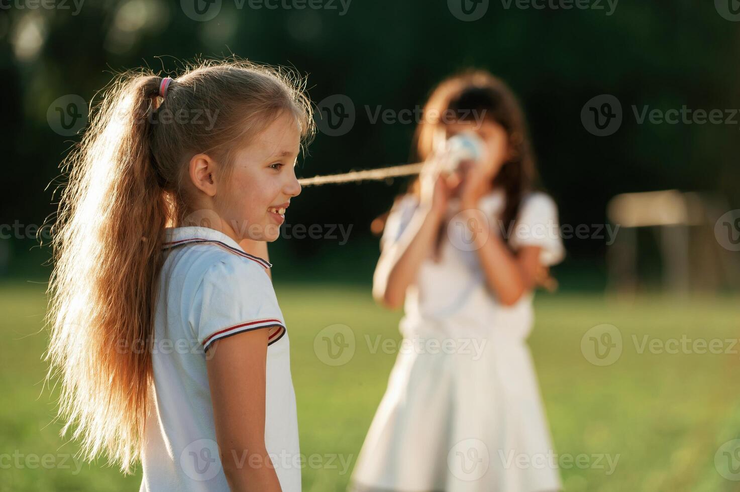 Using tin ,can,, telephone. Happy kids are on ,the summer field photo
