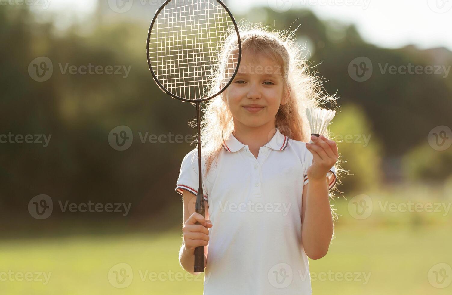 Cute little girl is with badminton racket,,, on the field photo