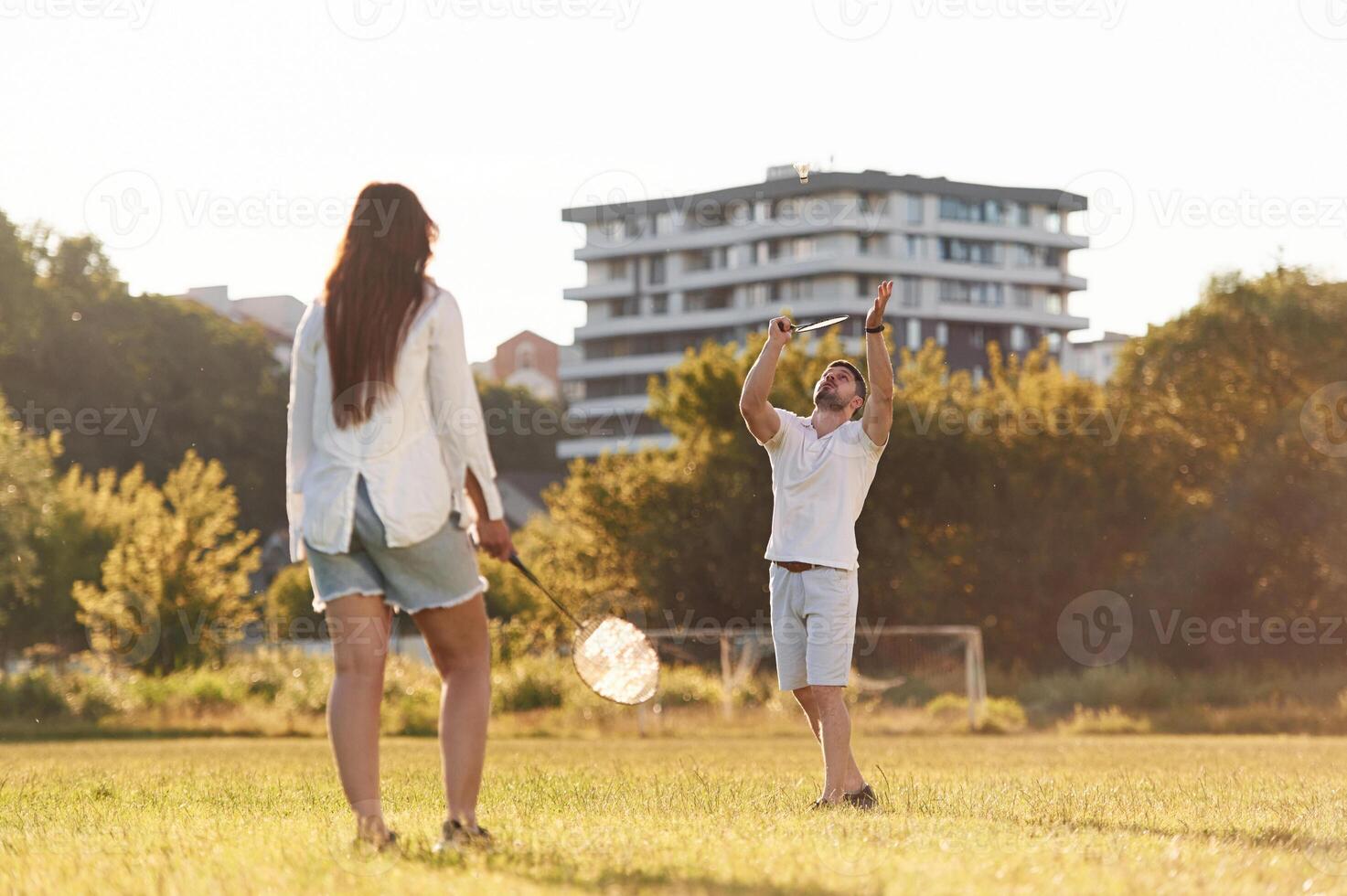 Conception, of sports ,,and hobby. Man with woman are playing badminton on the field photo