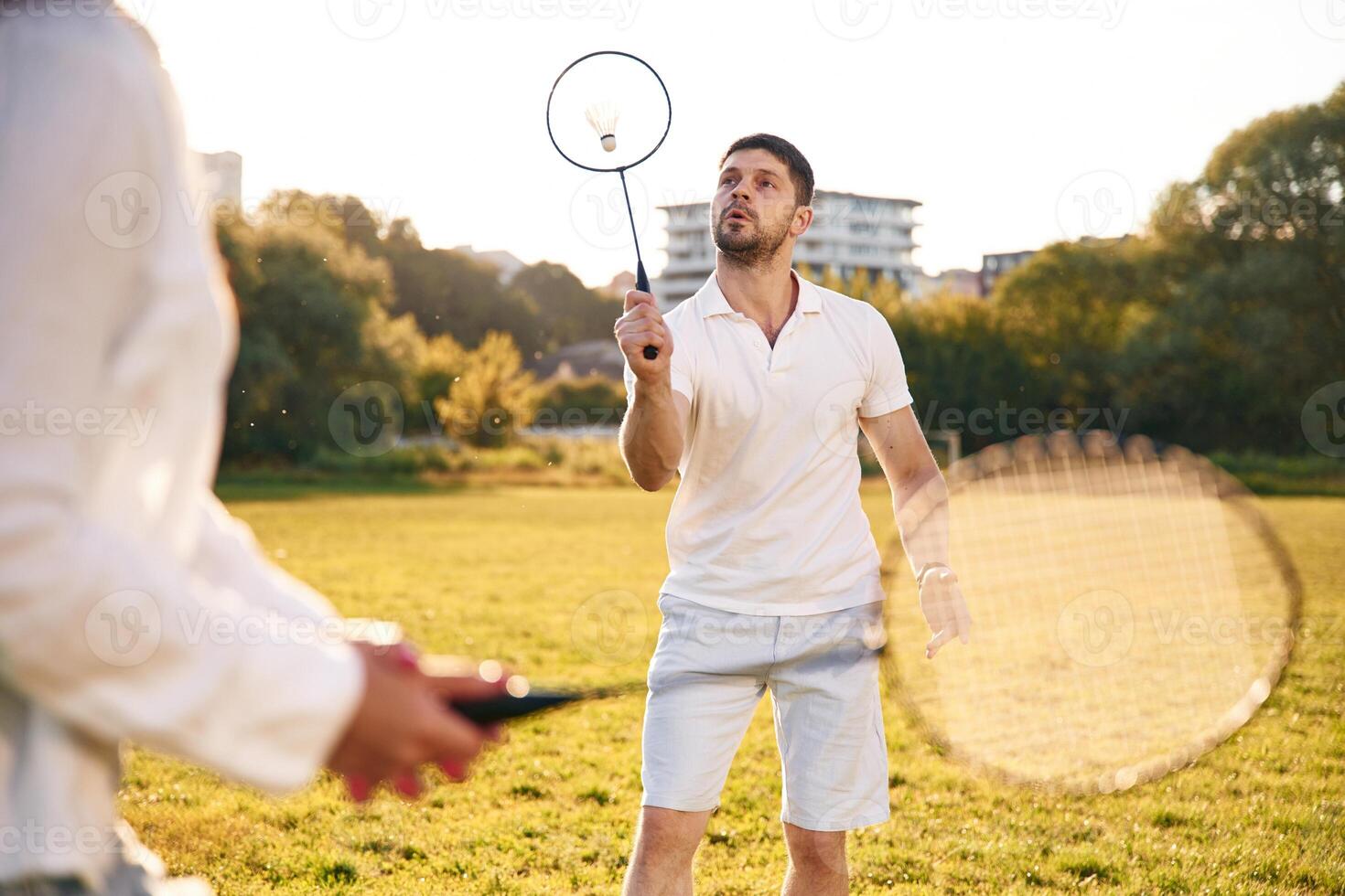 Conception, of sports and hobby. Man with woman are playing badminton on the field photo