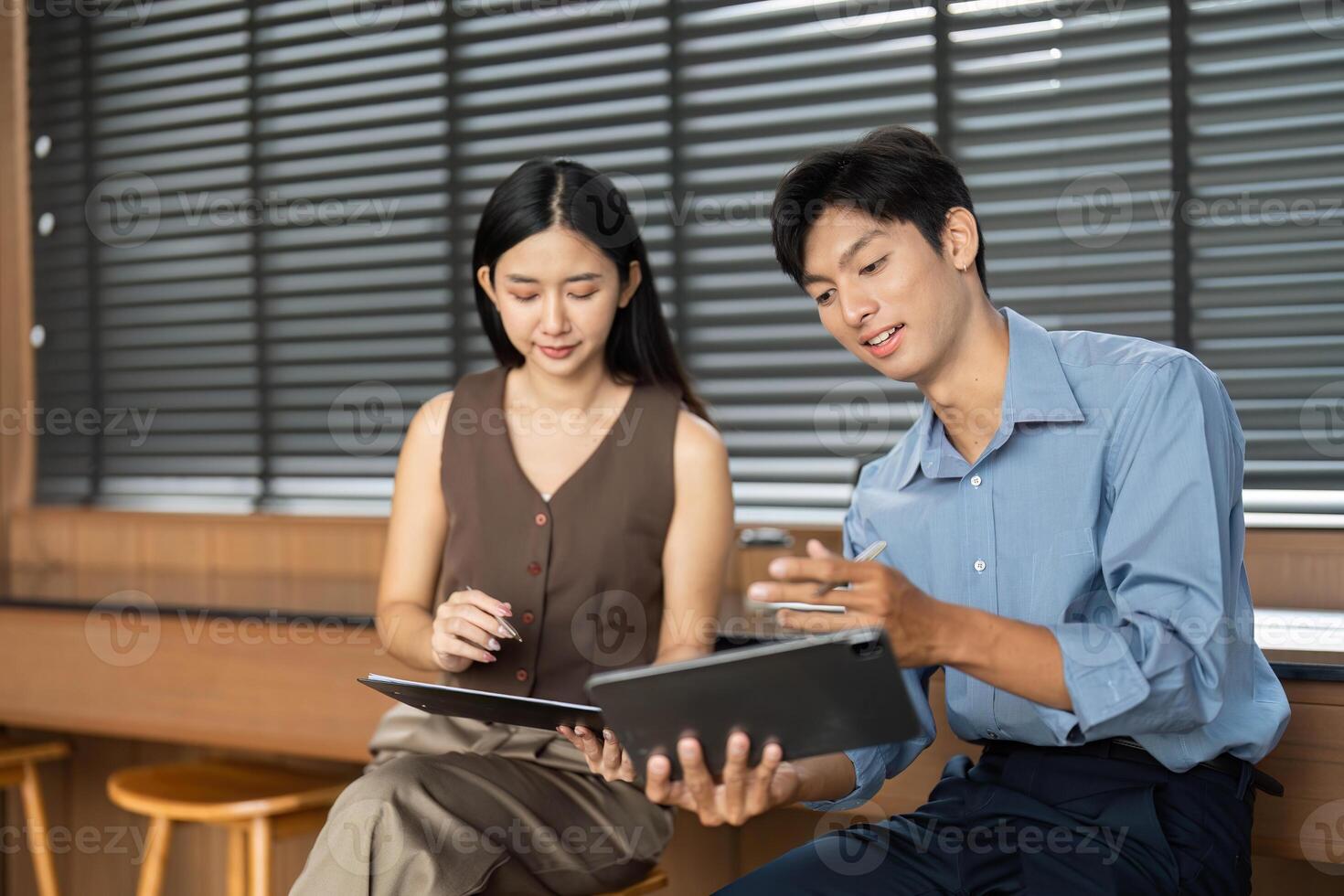 Business Collaboration and Discussion. Two professionals analyzing data on digital devices. photo