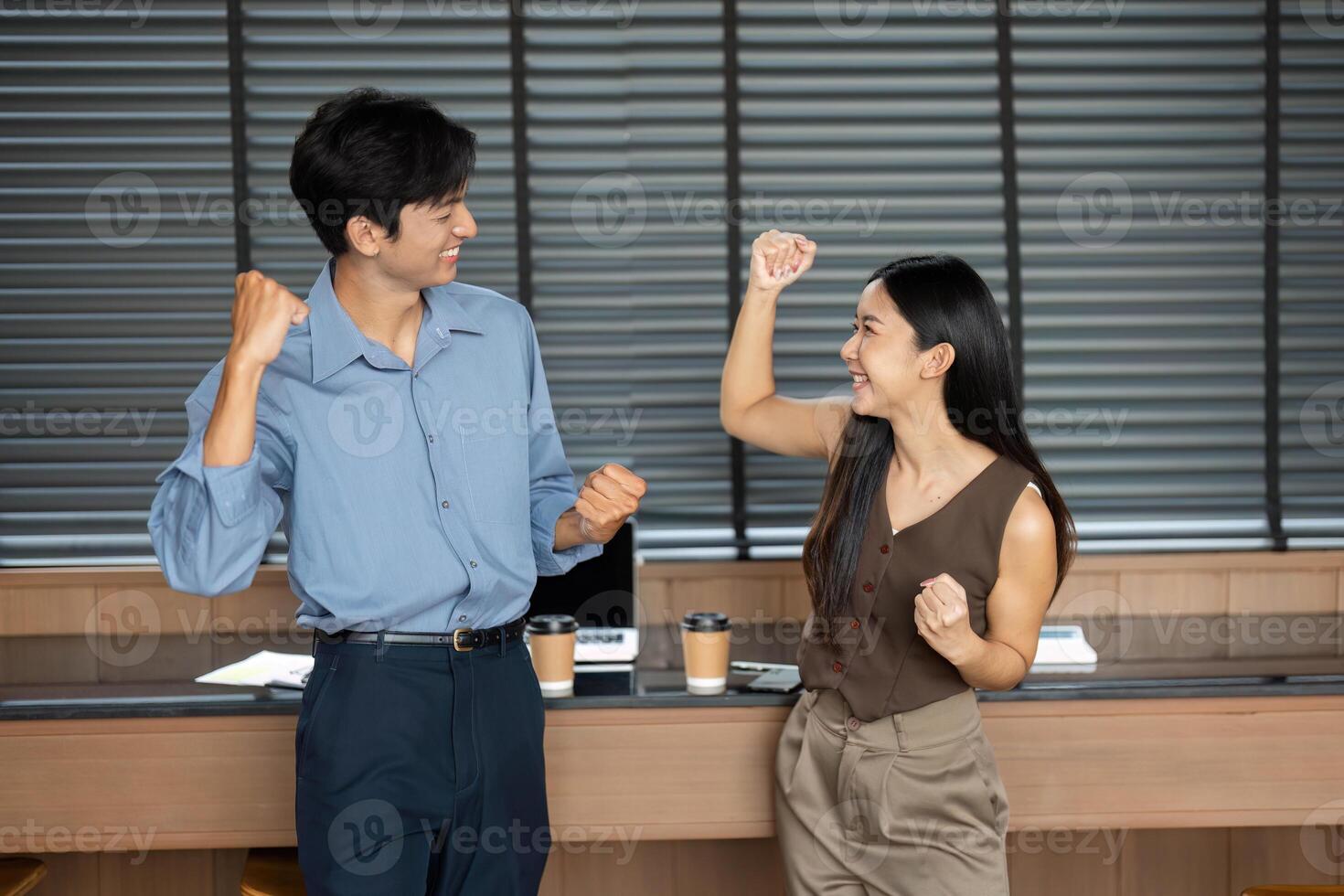 Business Motivation and Team Spirit. Colleagues celebrating success with fist pumps in an office. photo