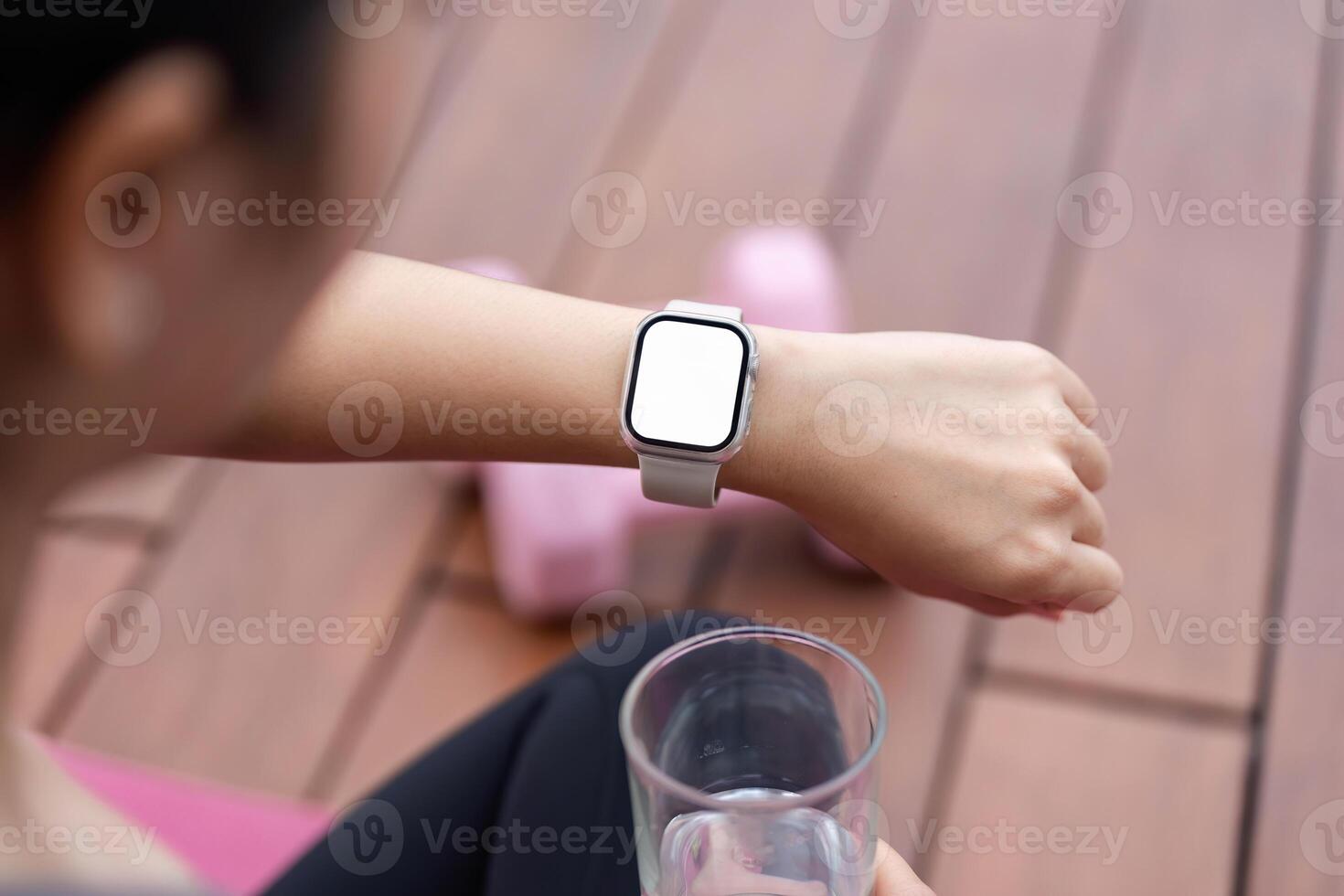 Yoga and Wellness. Young woman checking fitness data on smartwatch after workout. photo