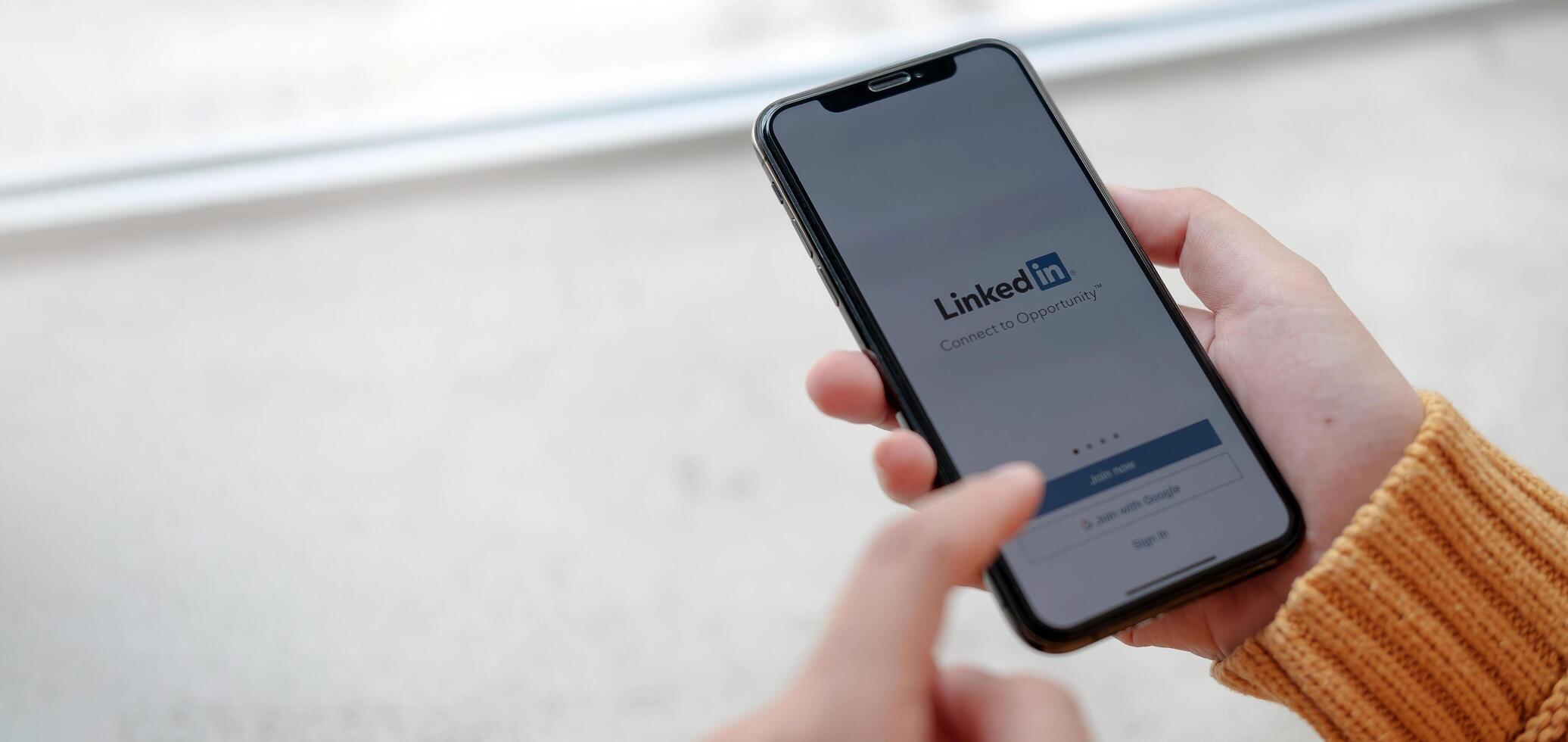 CHIANG MAI, THAILAND, APR 12, 2021 . A women holds Apple iPhone Xs with LinkedIn application on the screen.LinkedIn is a photo-sharing app for smartphones. photo
