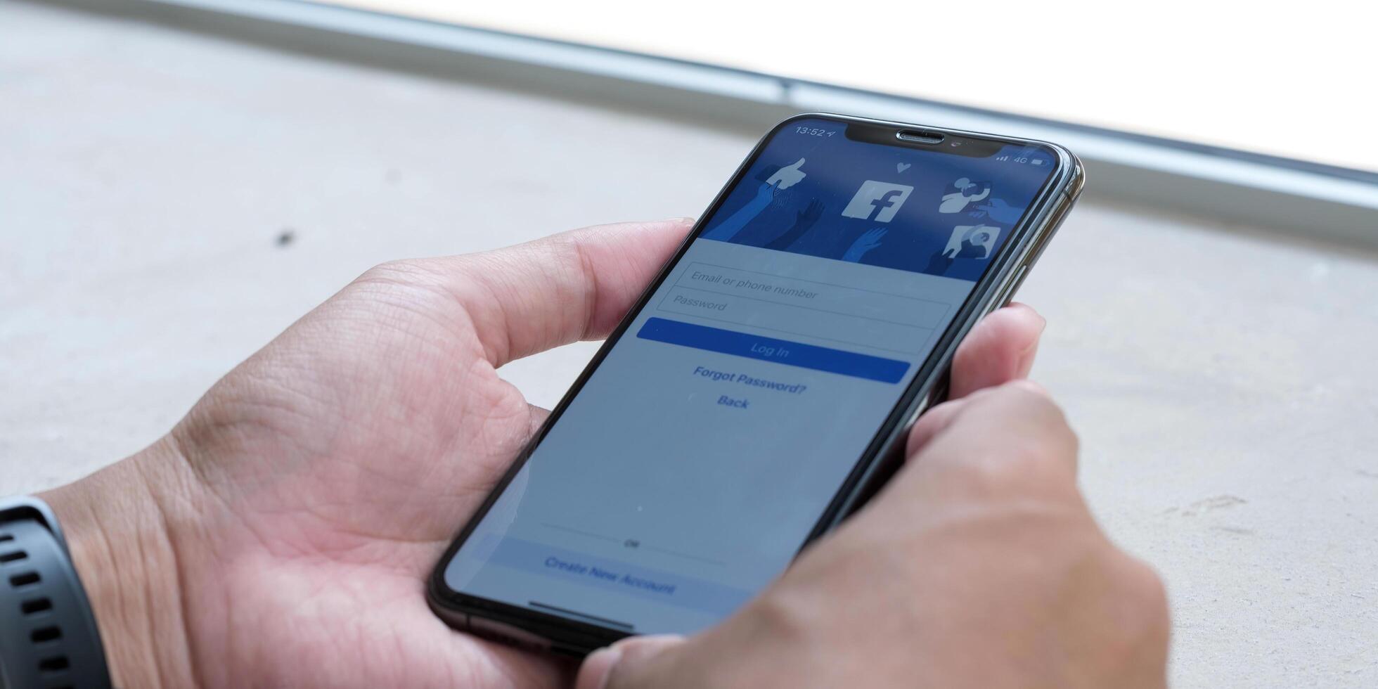 CHIANG MAI ,THAILAND MAY 18 2021 . Woman holding a iPhone X with social Internet service Facebook on the screen. photo