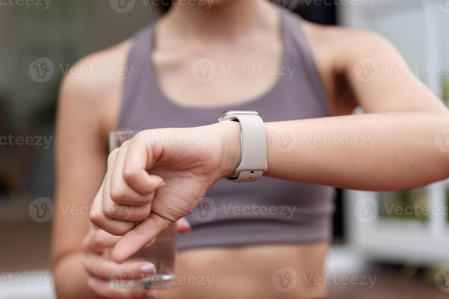 Yoga and Fitness. Woman using smartwatch to track health while enjoying hydration. photo