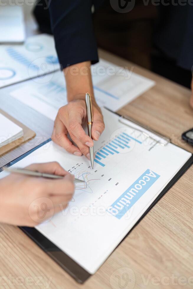 Analyzing Financial Data. Close-up of hands reviewing accounting charts and graphs in a business meeting. photo
