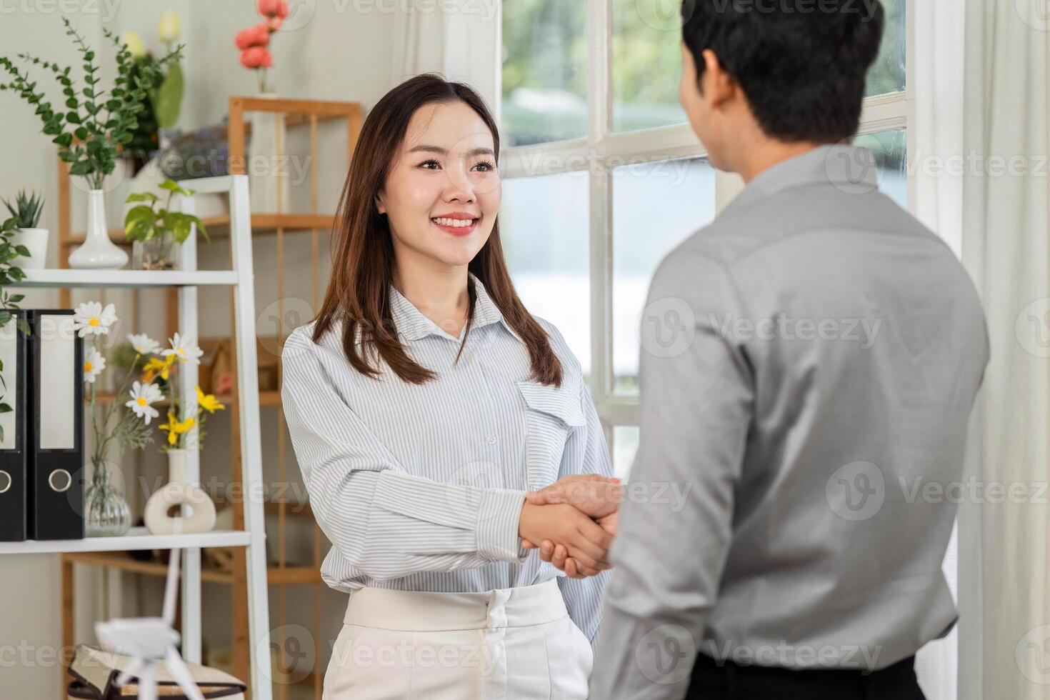 Professional Introduction. Woman shaking hands with a colleague in a bright office. photo