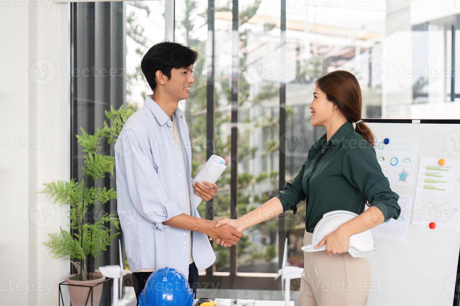 Professional Handshake in Sustainable Engineering. Young engineers finalizing ESG project plans in office. photo