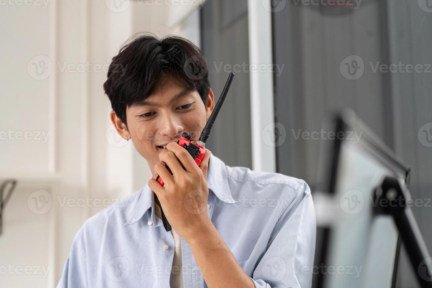 Communication in Construction. Young engineer using walkie-talkie for project coordination. photo