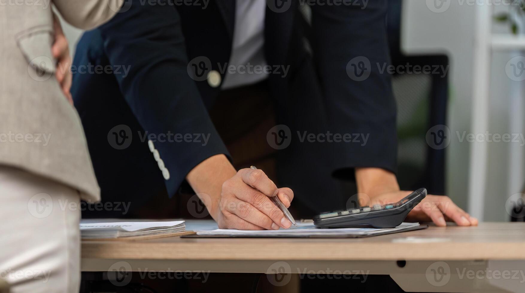 Financial Strategy Implementation. Businessman writing notes while discussing financial reports. photo