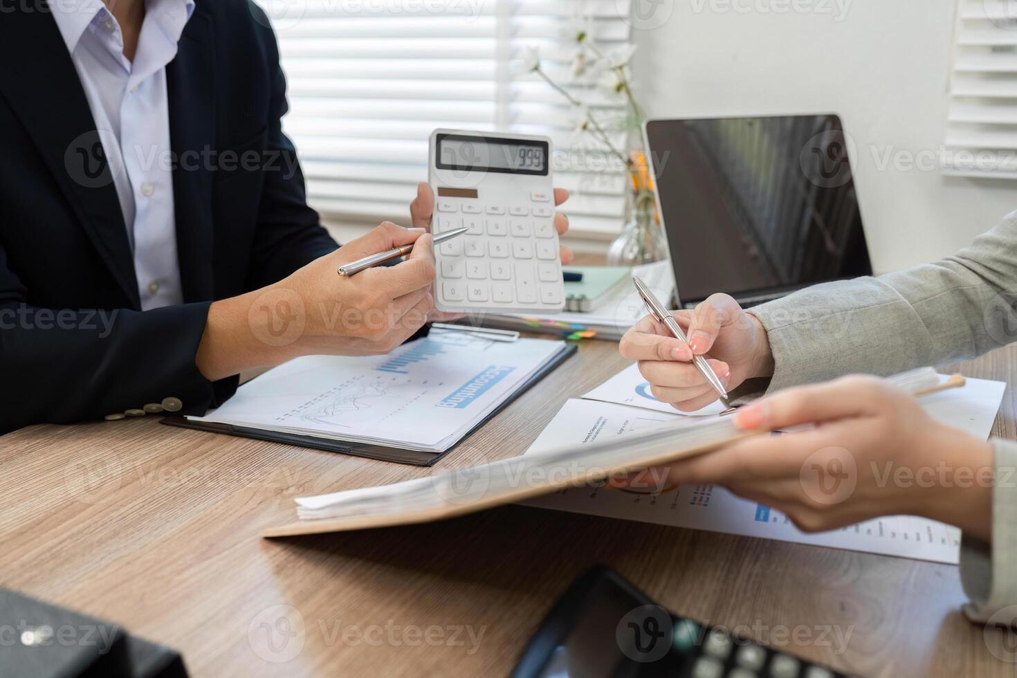 Financial Consultation and Analysis. Business professionals discussing financial data with calculator. photo