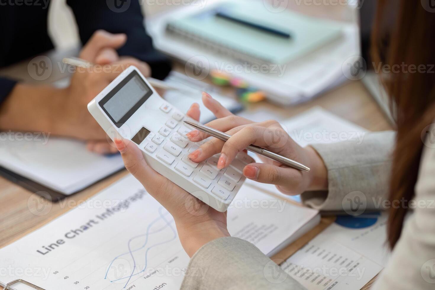 Calculator Usage in Financial Analysis. Professional woman calculating data during a meeting. photo