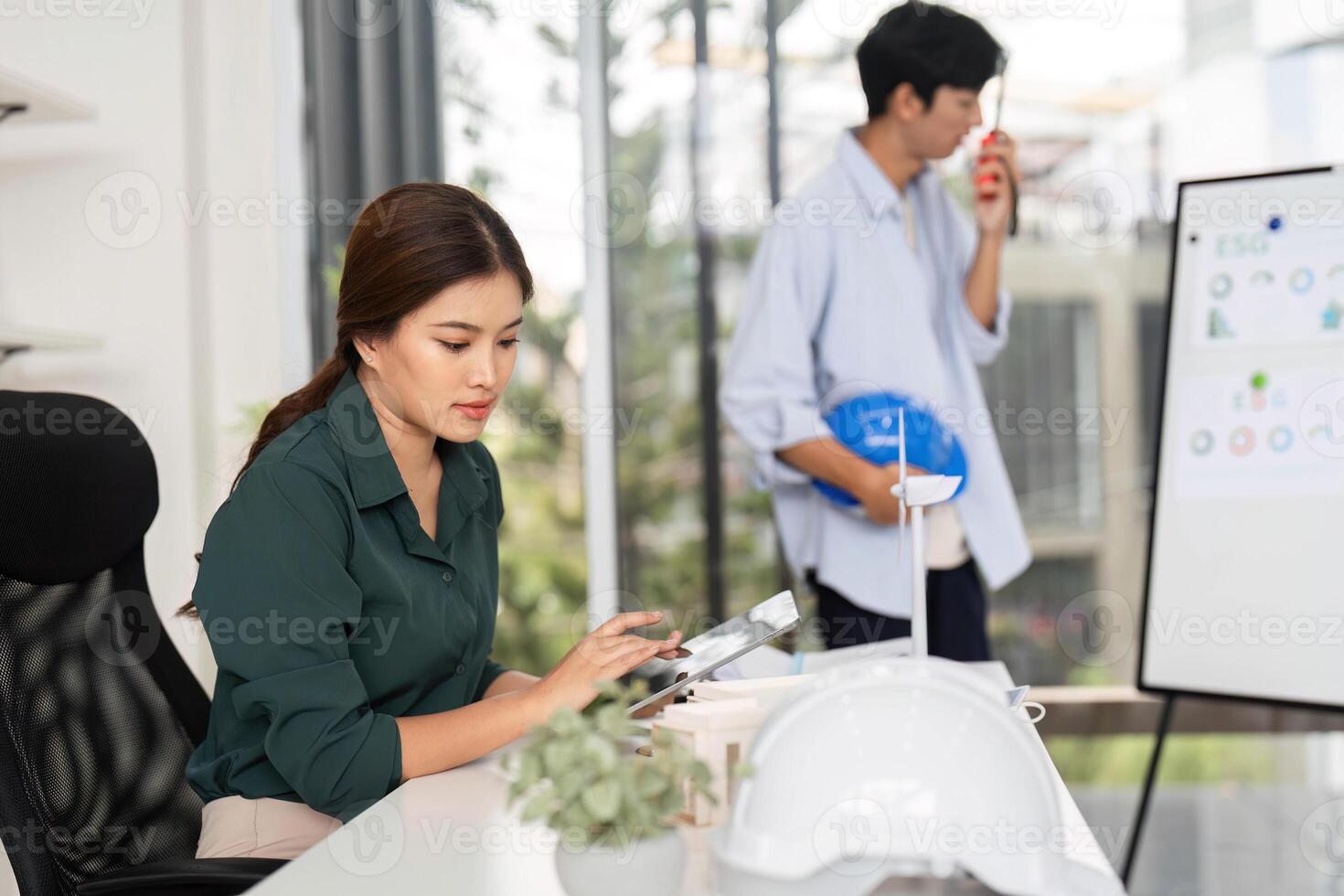 Focused Engineer Working on Tablet. A female engineer reviews project plans in a modern office. photo
