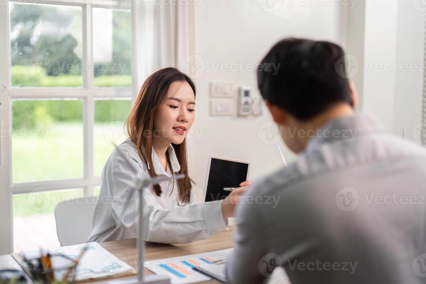 ESG Focused Business Discussion. Woman presenting sustainability ideas using a tablet in a corporate meeting. photo