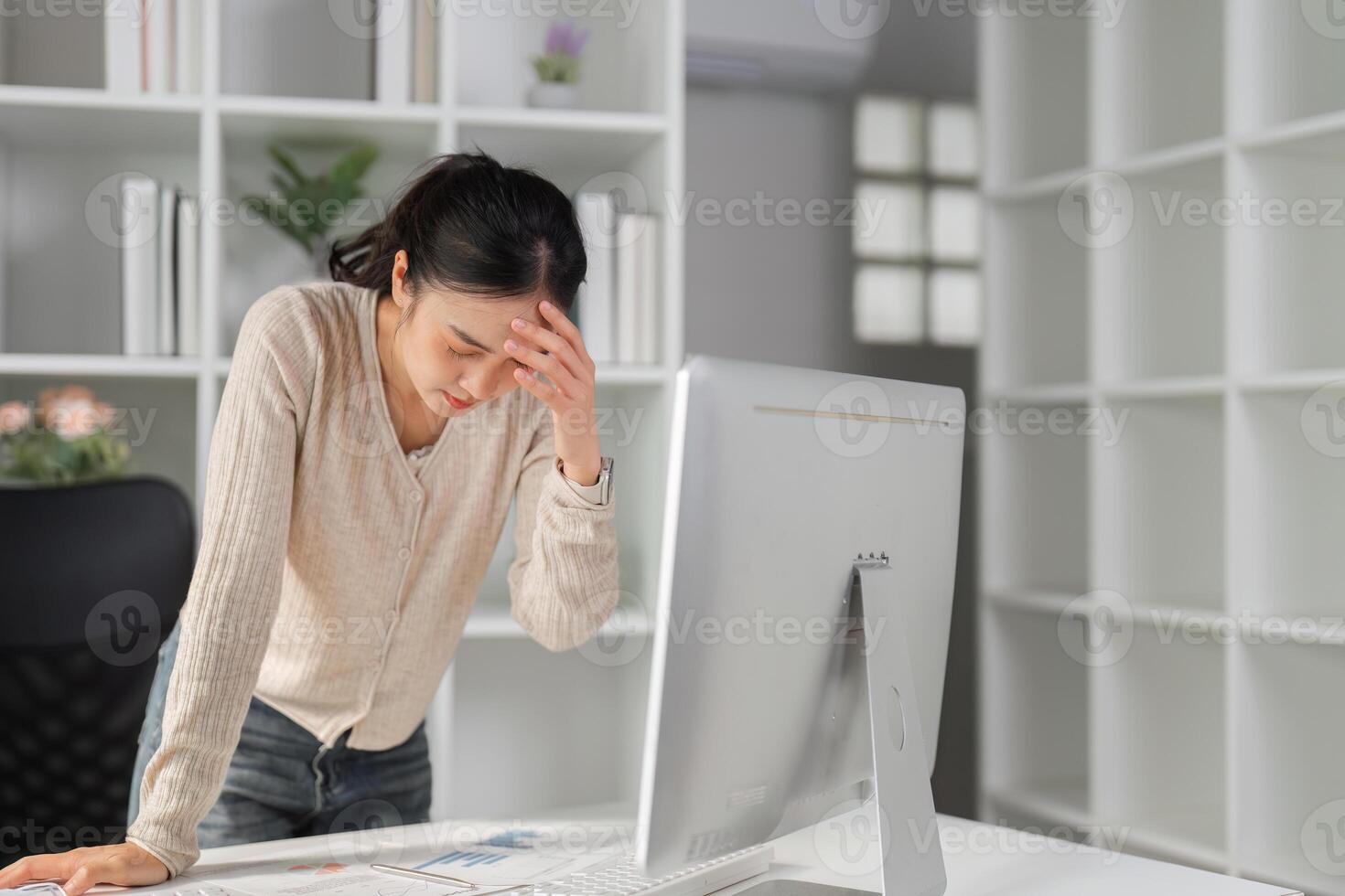 Woman feeling stressed and frustrated while working at her office desk. photo