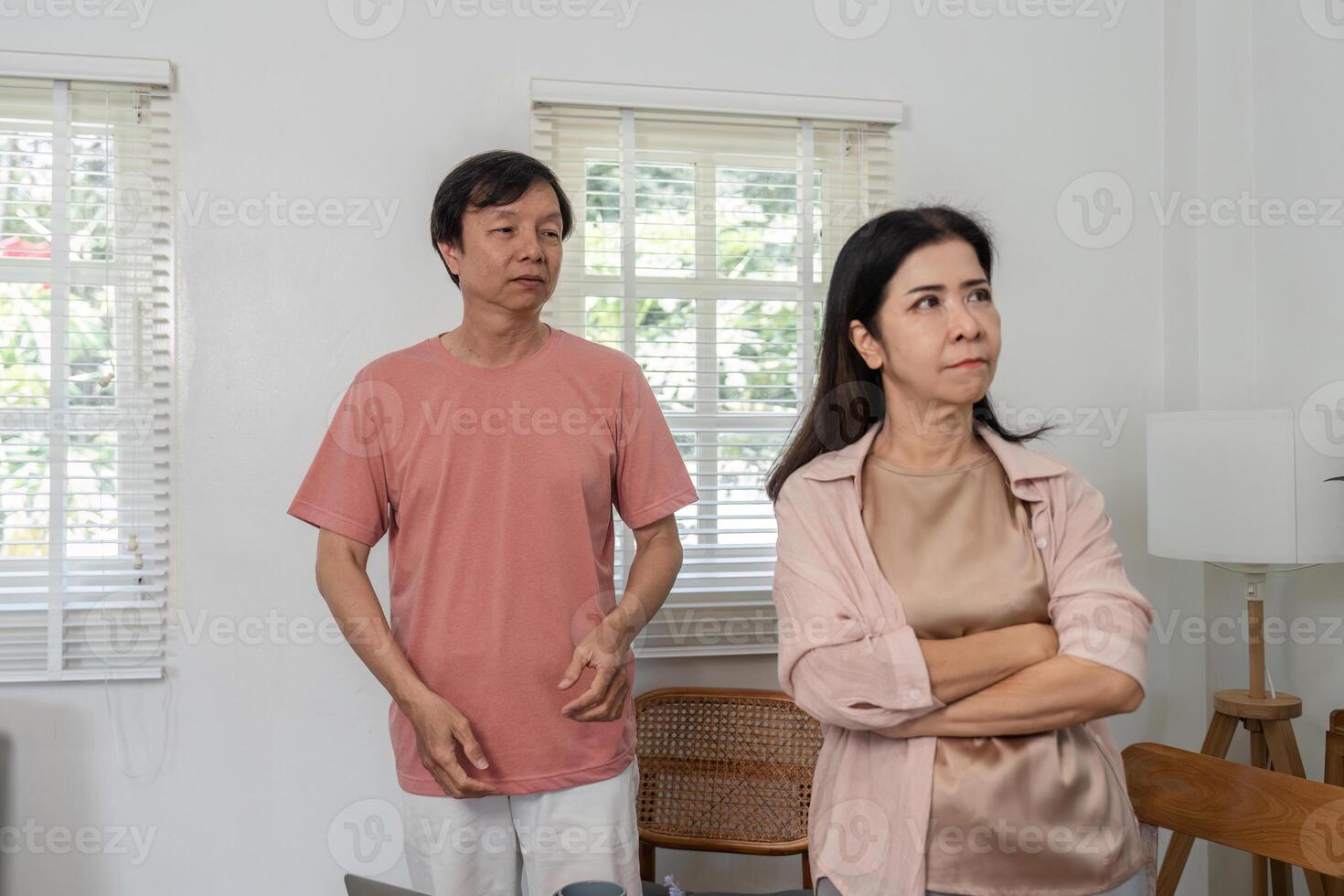 Middle-aged couple experiencing a tense moment indoors during a disagreement. photo