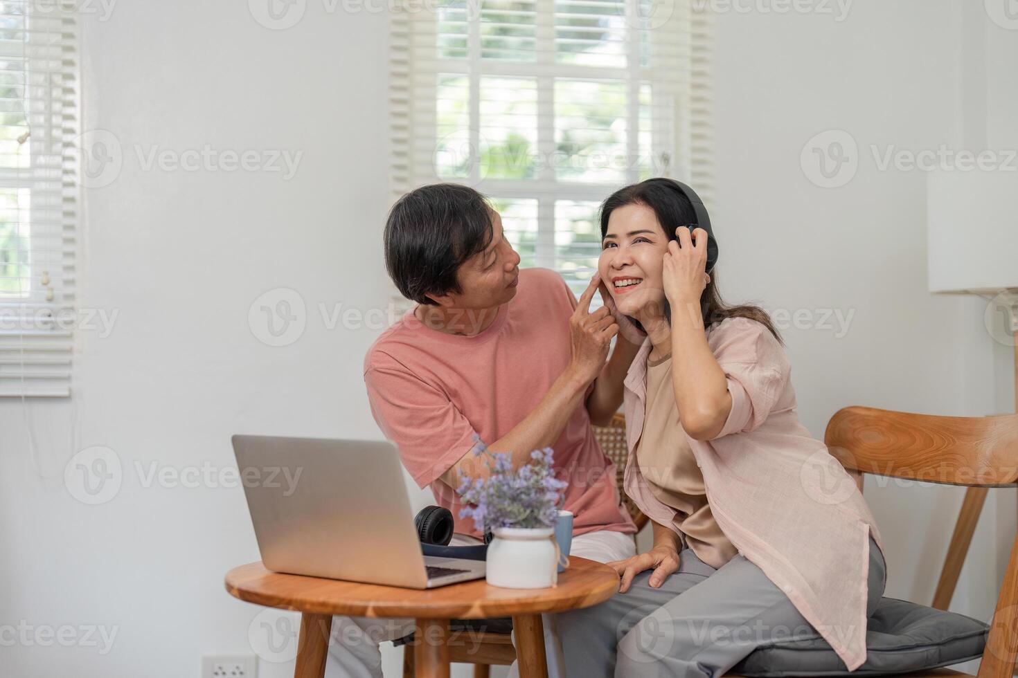 Older couple sharing affection while using a laptop at home. photo