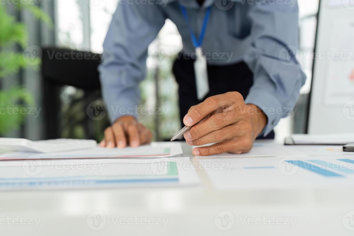 Focused Businessman Analyzing Reports. Professional reviewing financial documents on a desk. photo