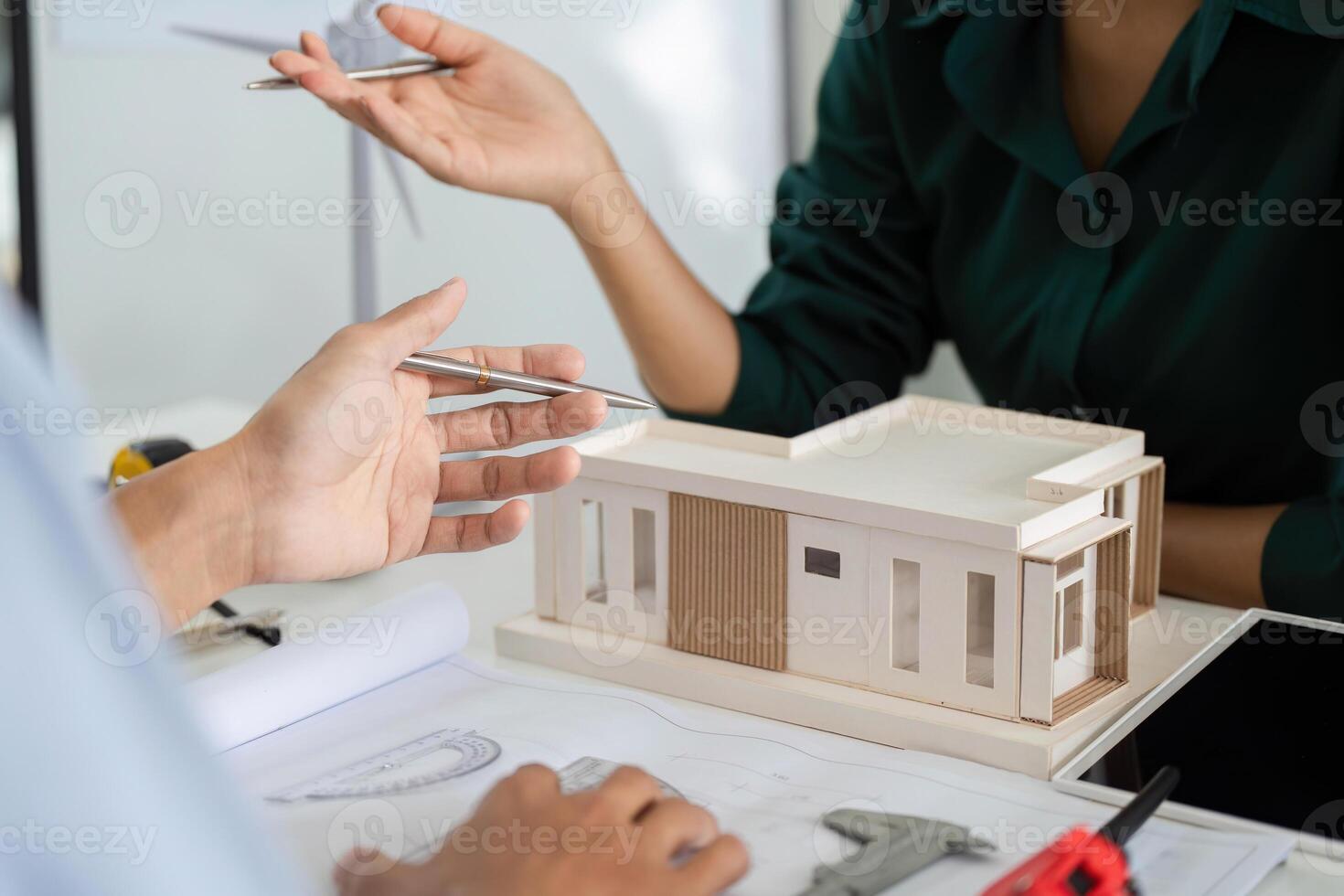 Sustainability in Architecture. Professionals discussing a model building with ESG focus. photo