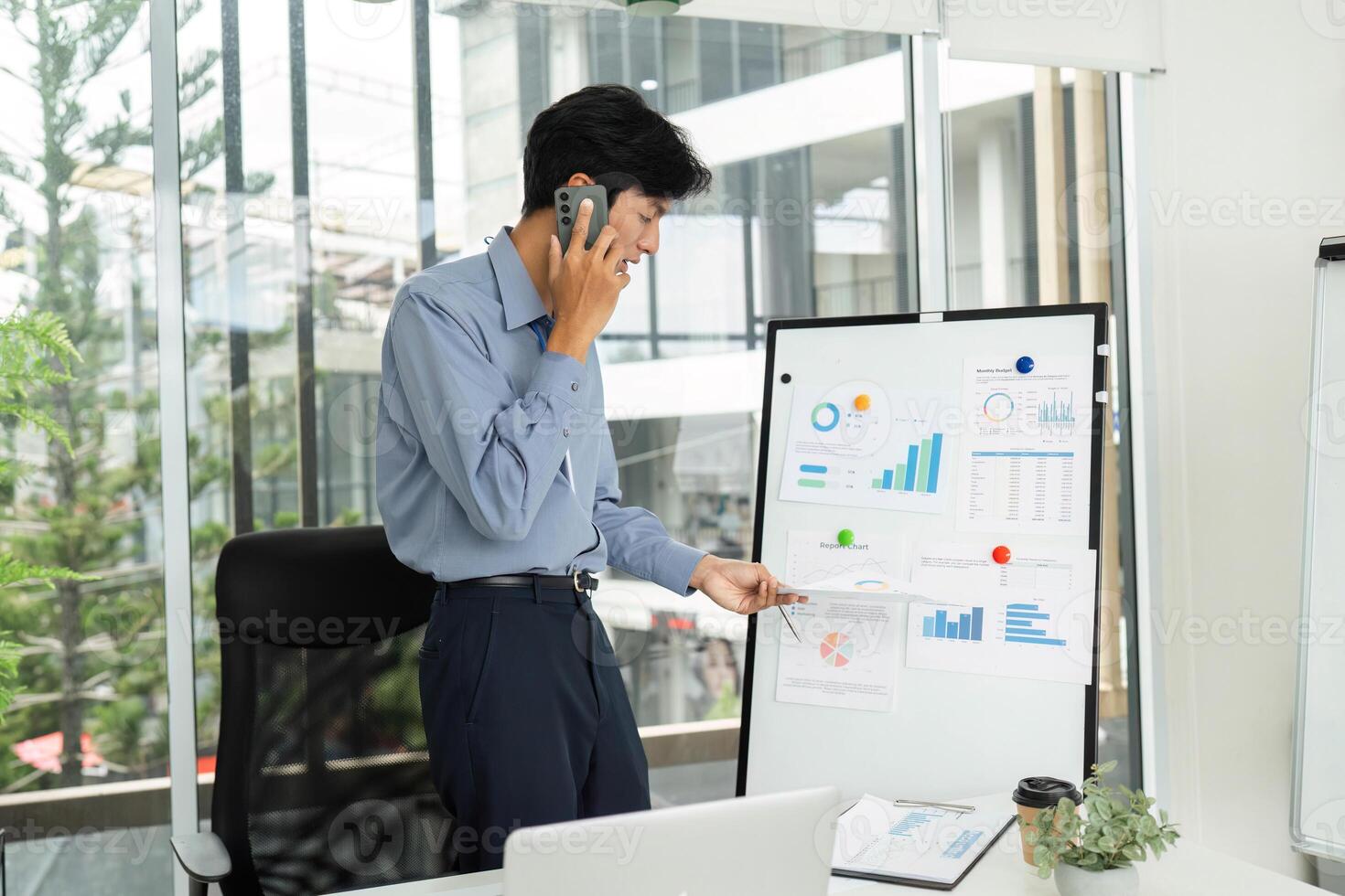 Business Professional Engaged in Phone Call While Presenting Financial Data photo