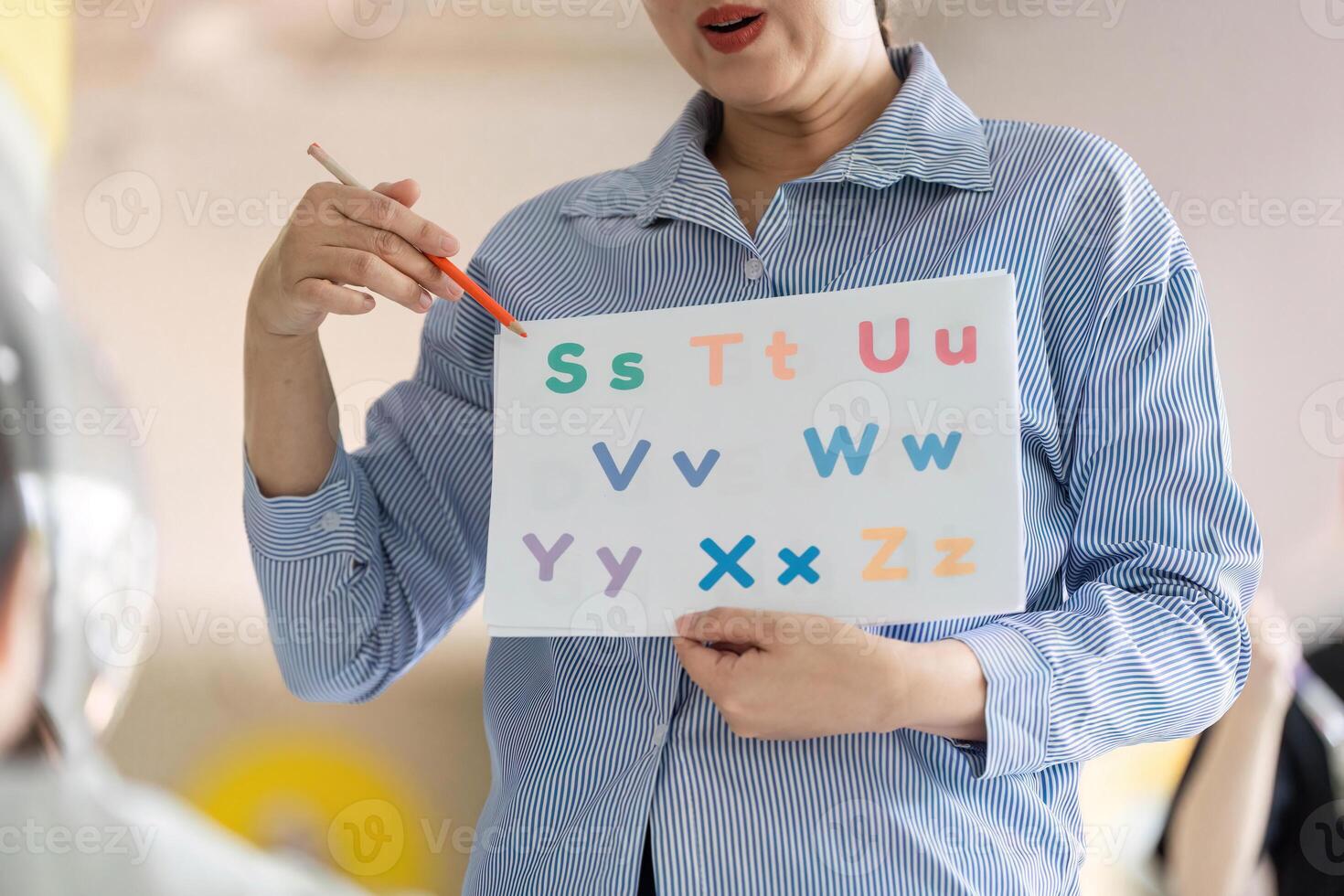 Back to School. Teacher Engaging Young Students with Alphabet Learning photo