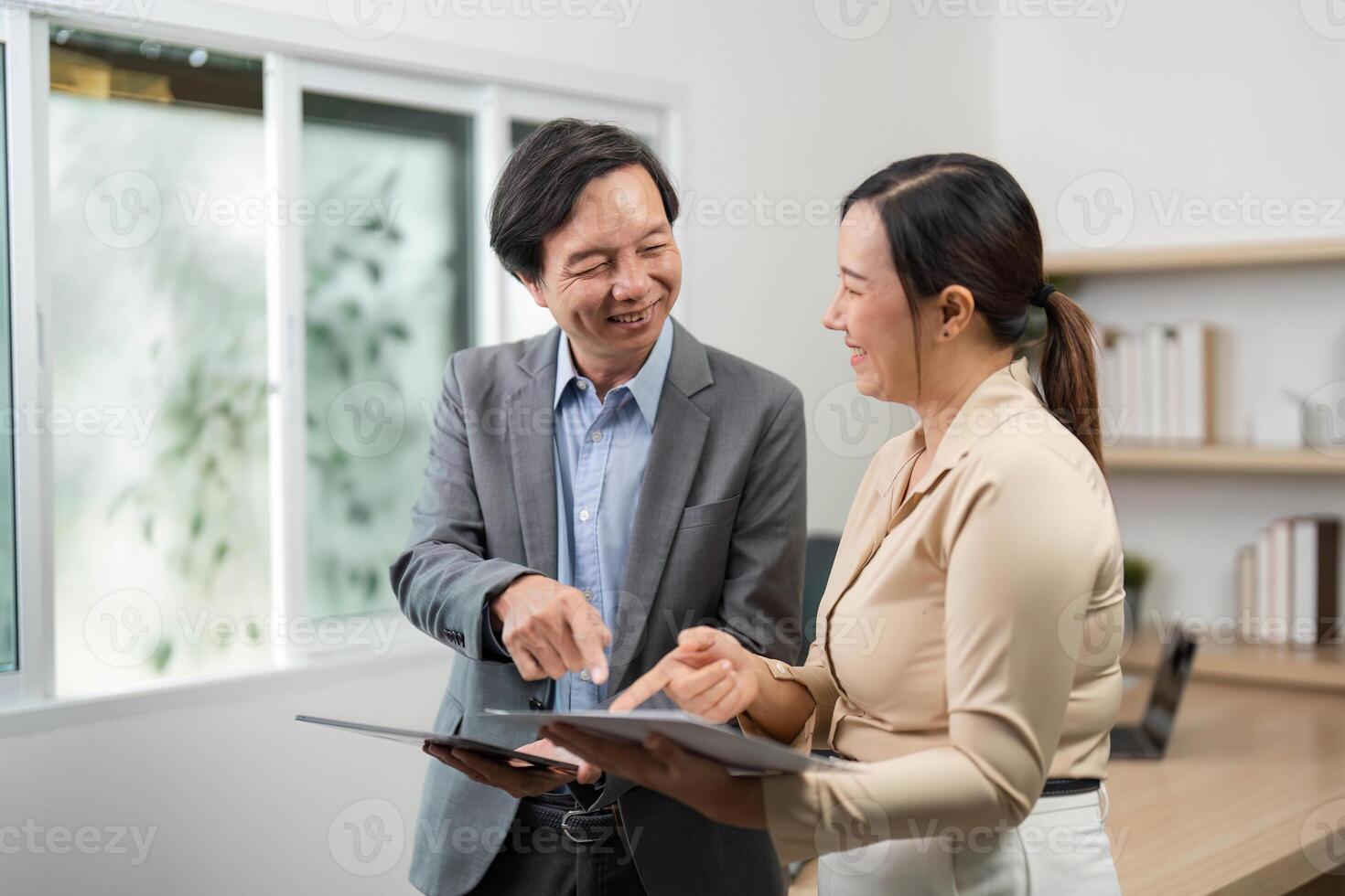 Professional Interaction and Document Review. Businessman and businesswoman sharing insights in a modern office. photo